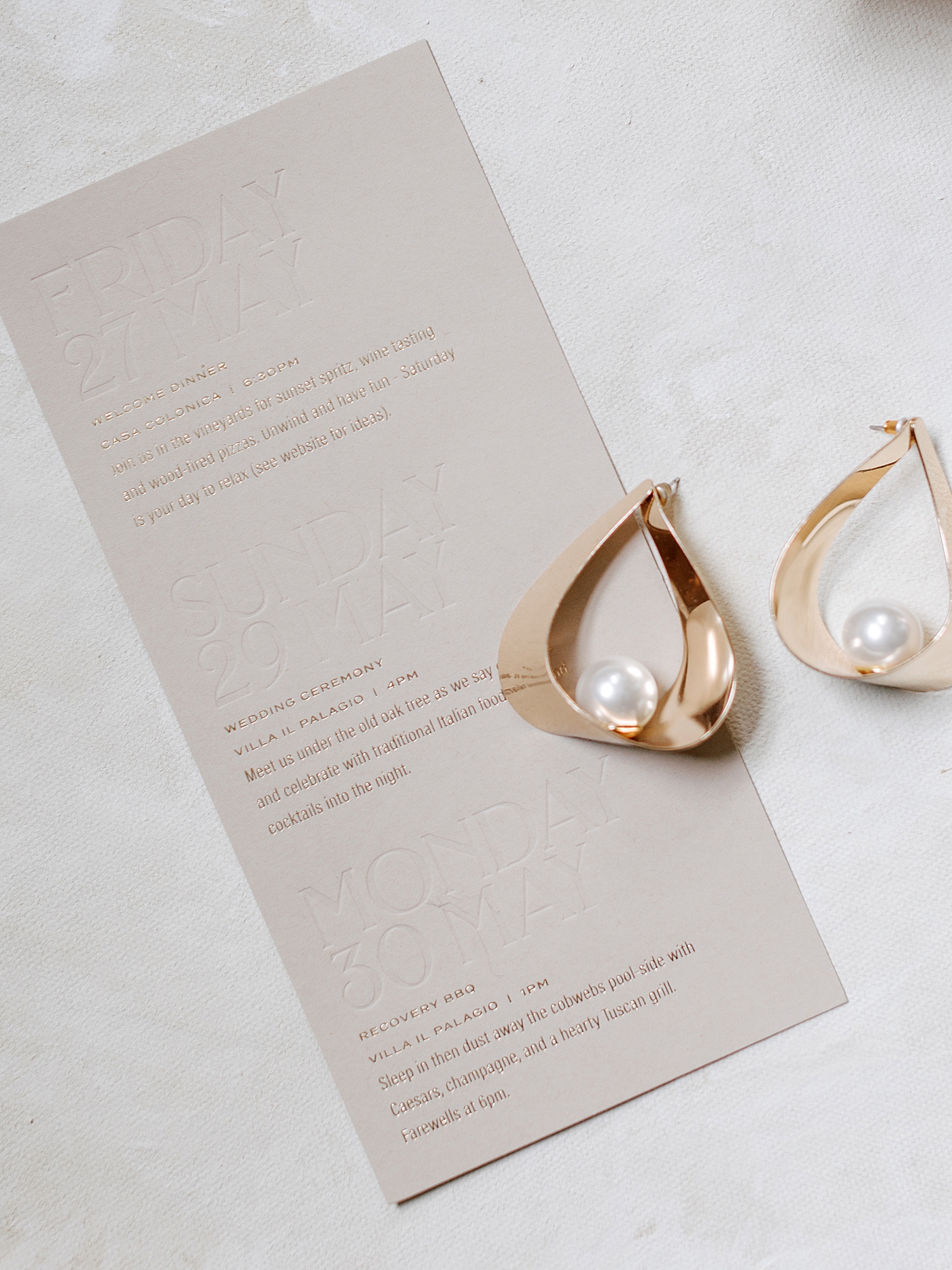 Gold and pearl earrings on a wedding invitation | Photo by NYC Wedding Photographer Hope Helmuth 