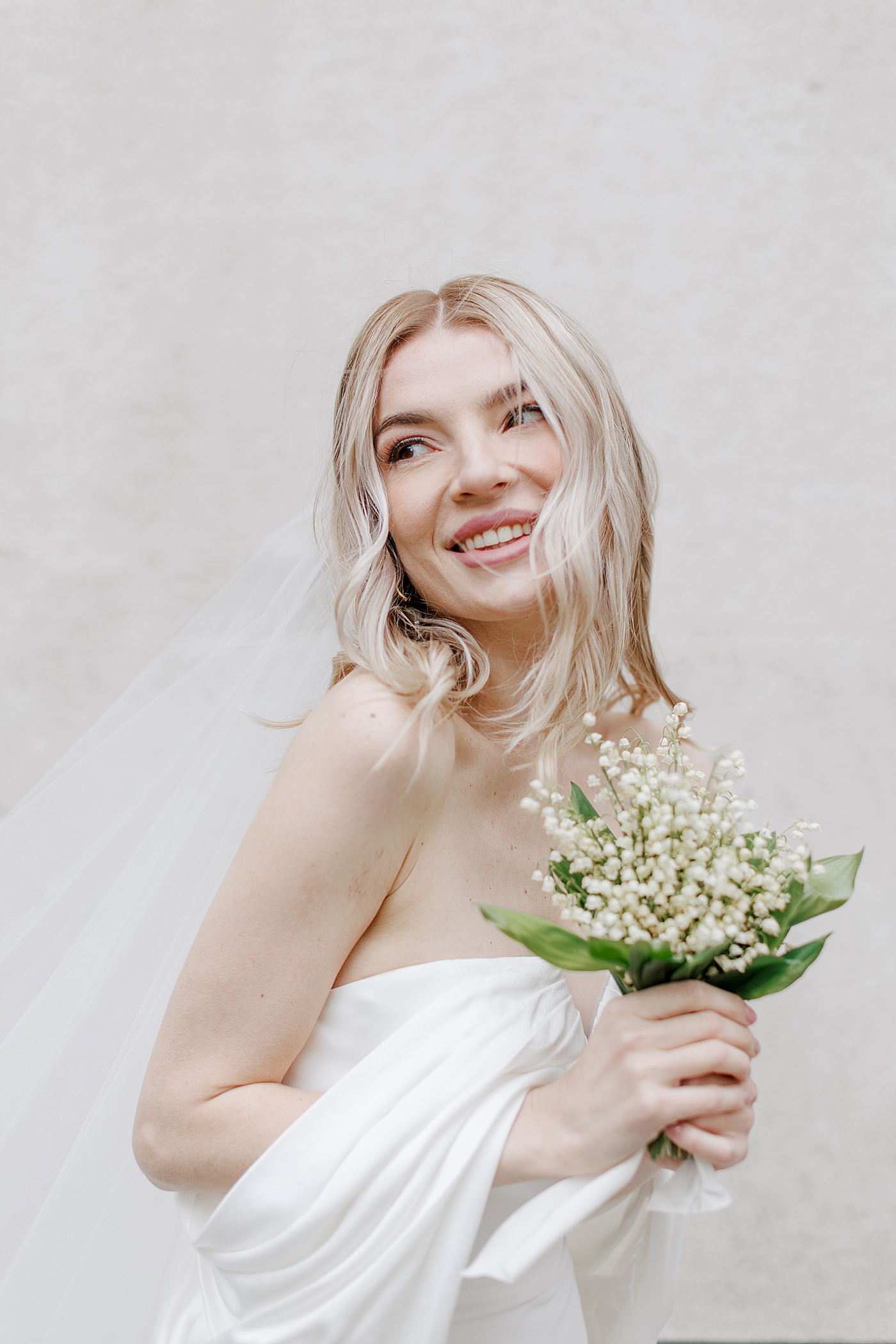 Bride smiling holding her bouquet | Photo by NYC Wedding Photographer Hope Helmuth