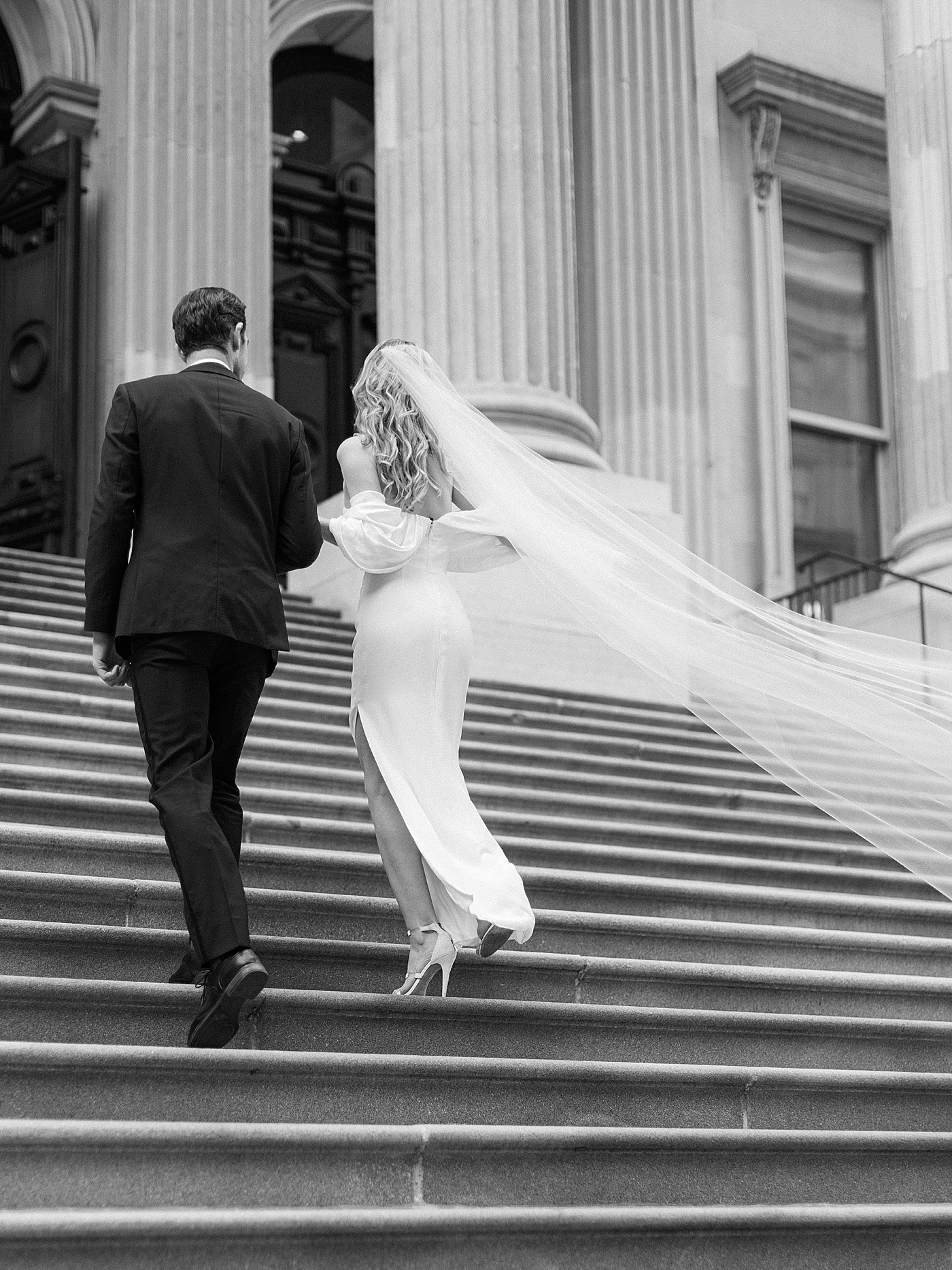 Bride and groom walking up stairs | Photo by NYC Wedding Photographer Hope Helmuth