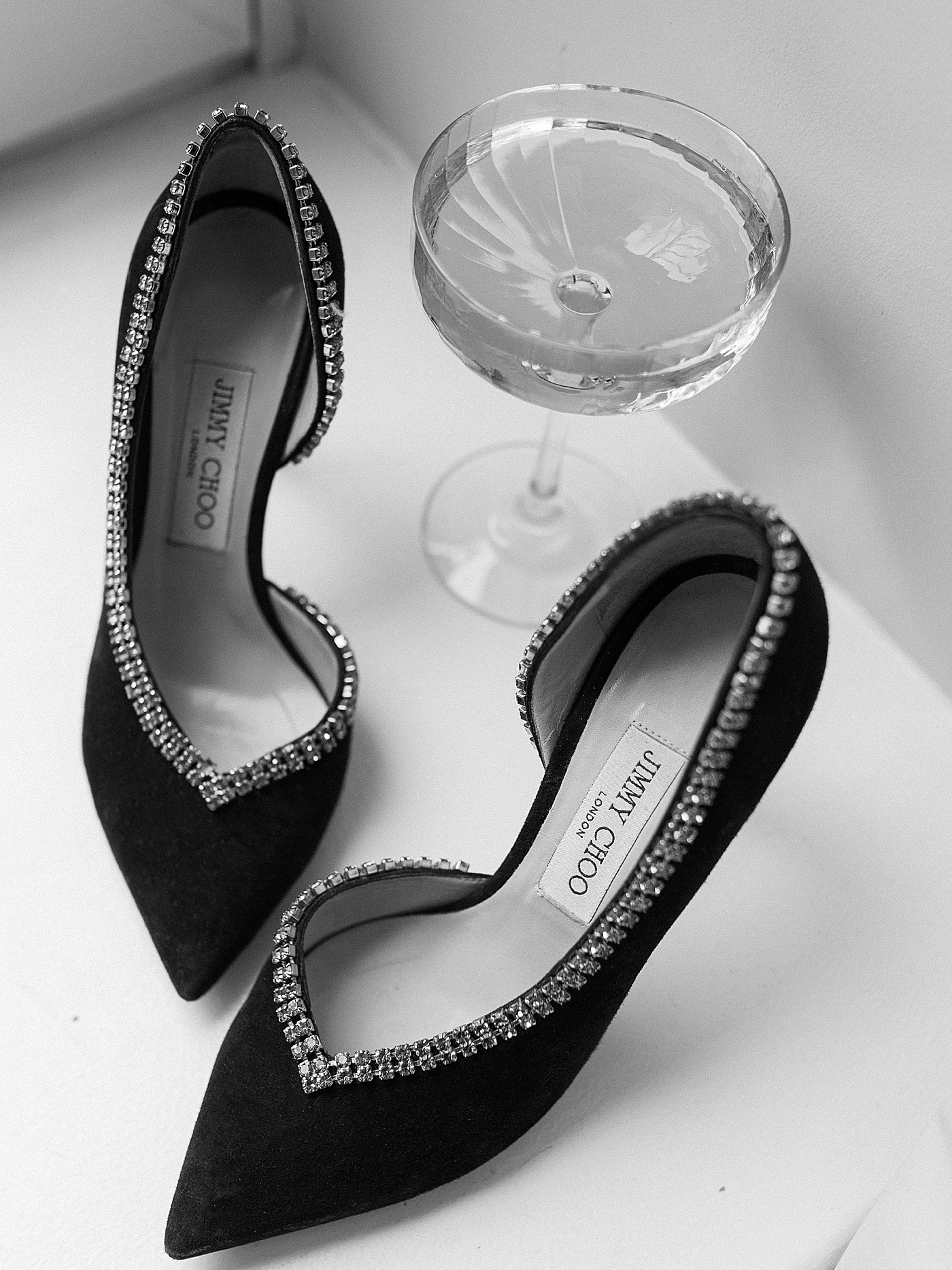Black Jimmy Choo heels and a champagne flute | Photo by NYC Wedding Photographer Hope Helmuth 