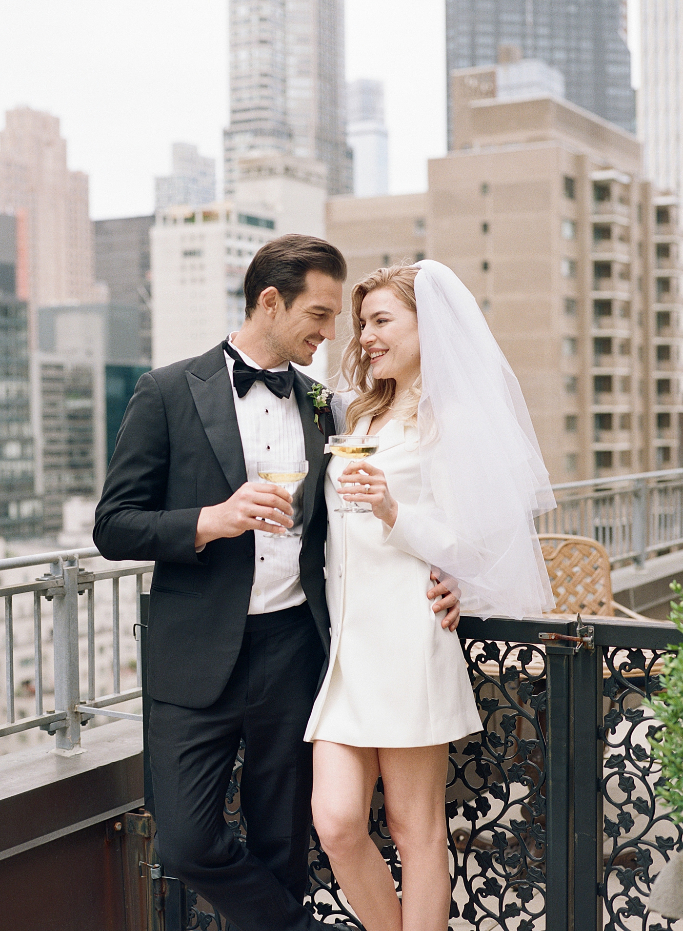 Bride and groom toasting on a balcony in NYC | Photo by Hope Helmuth Photography