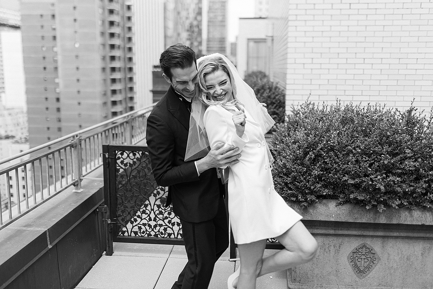 Bride and groom being playful on a balcony | Photo by Hope Helmuth Photography