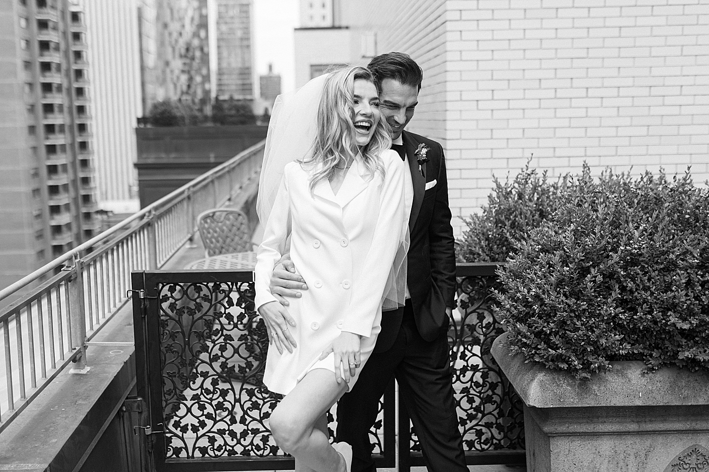Bride and groom being playful on a balcony in NYC | Photo by Hope Helmuth Photography