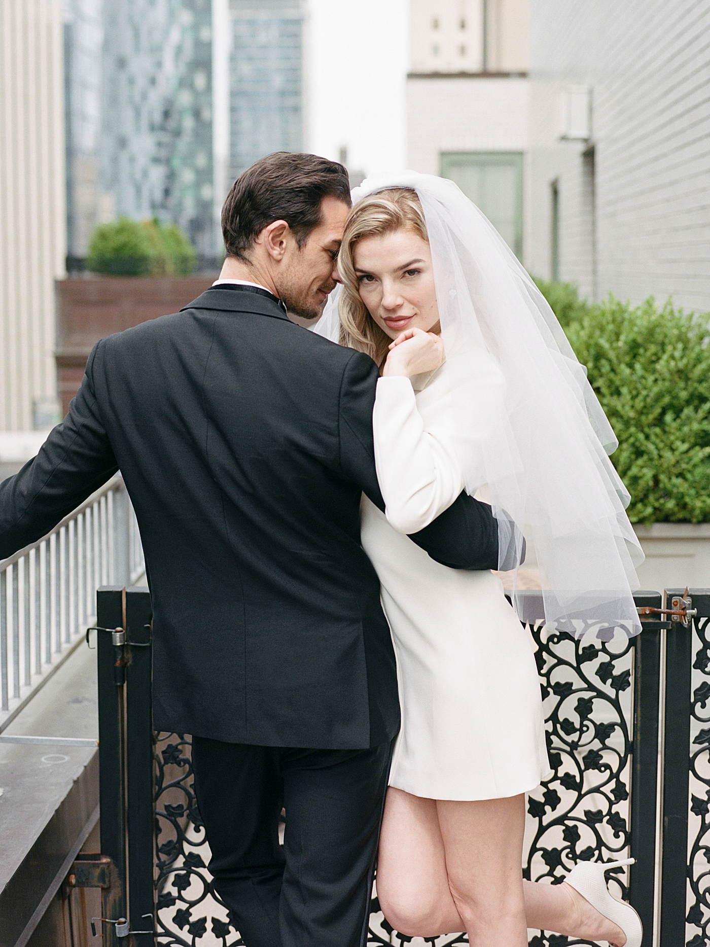 Bride and groom snuggling on a balcony | Photo by NYC Wedding Photographer Hope Helmuth 