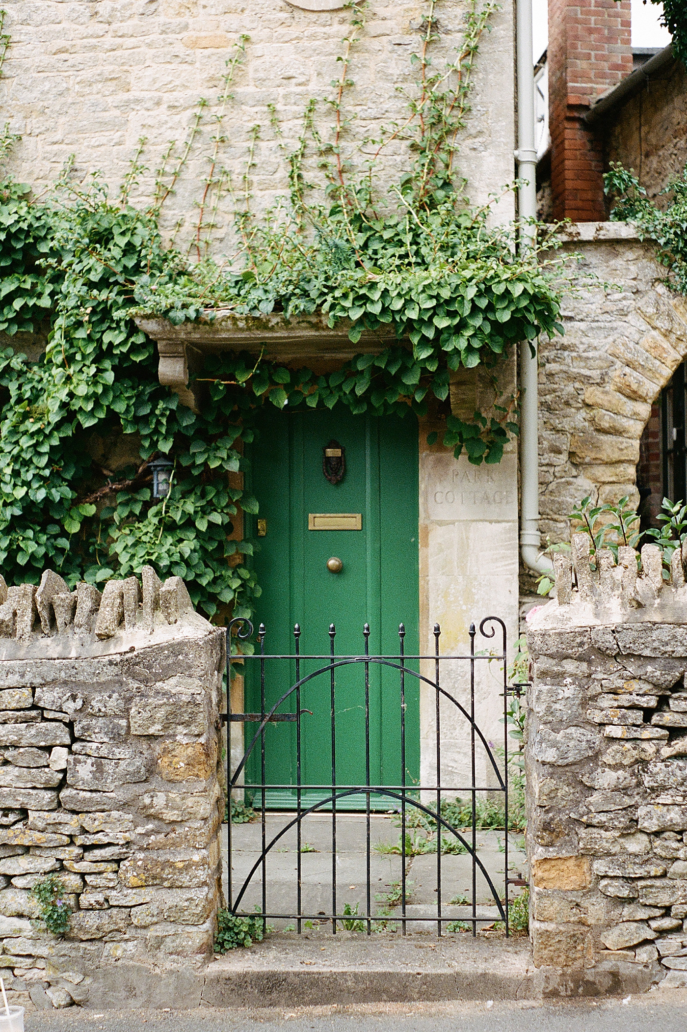 Green door in stone building with vines | Photo by Hope Helmuth Photography