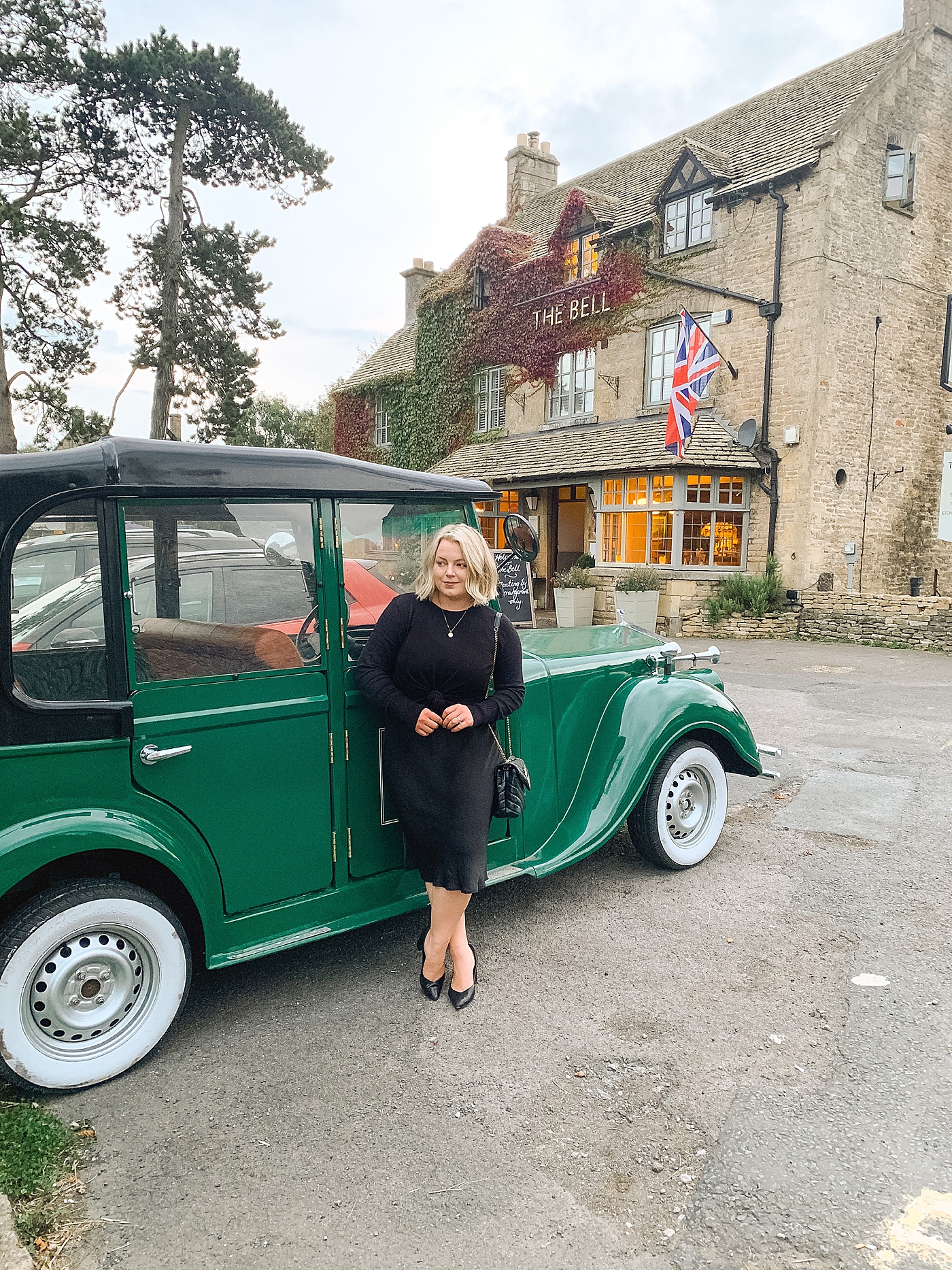 Woman in black with blonde hair near a green car | Photo by Cotswolds Wedding Photographer Hope Helmuth 