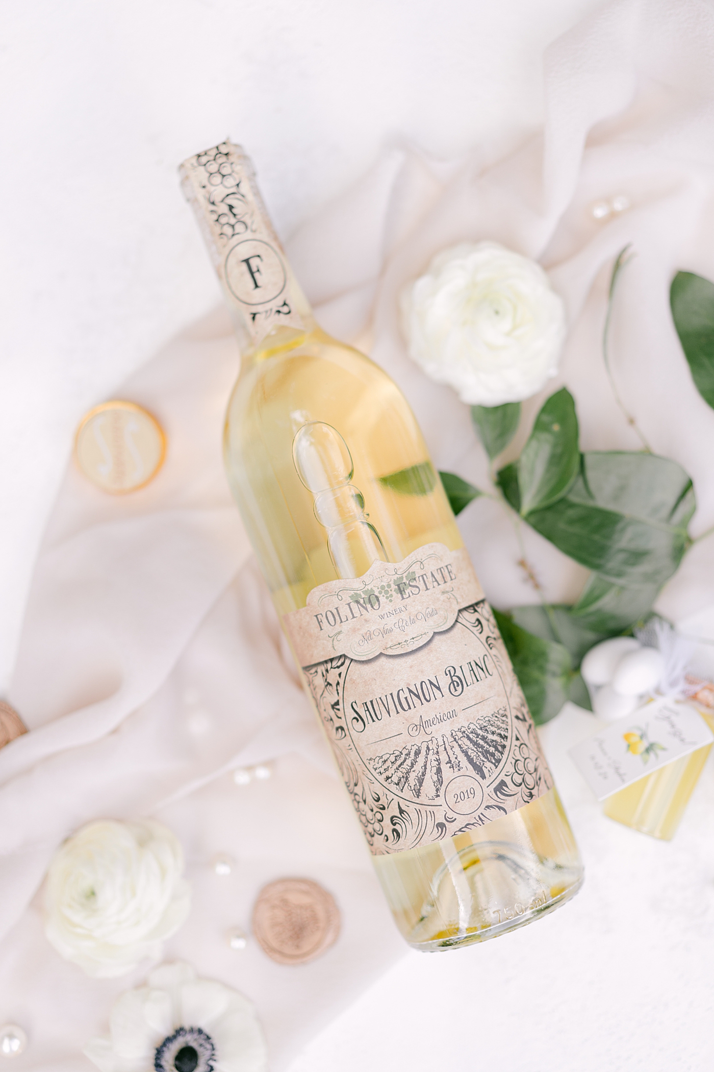 Bottle of white wine from Folino Estate with flowers | Photo by Hope Helmuth Photography