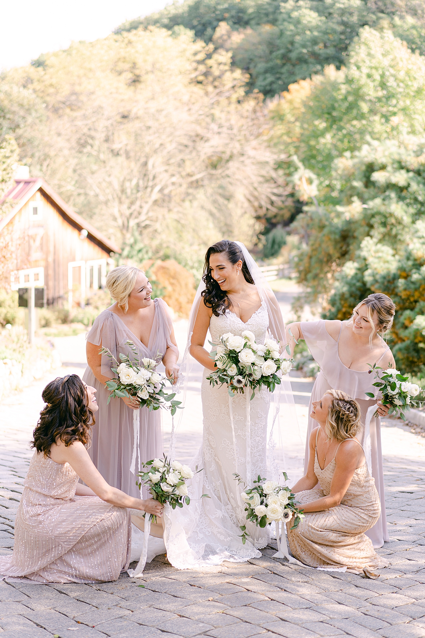 Bridesmaids adjusting brides dress | Photo by Hope Helmuth Photography