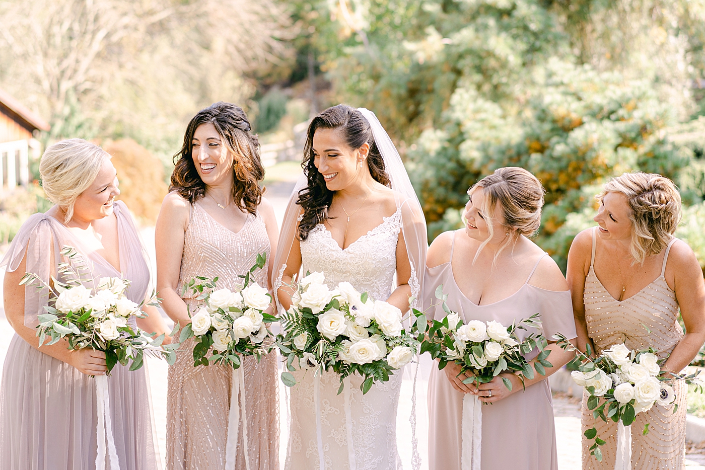 Bridesmaids smiling holding bouquets | Photo by Hope Helmuth Photography