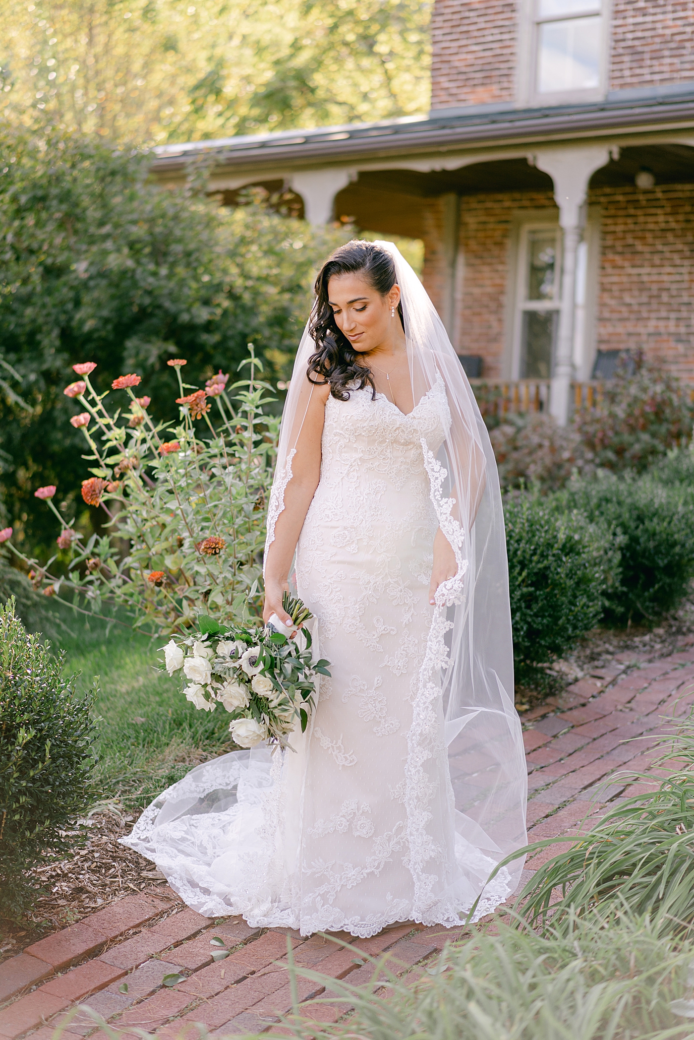 Bride with veil holding her bouquet | Photo by Hope Helmuth Photography