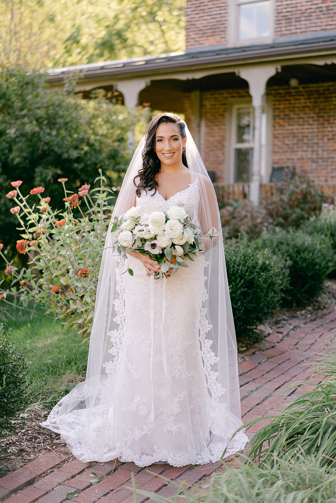 Bride posing for photos near zinnia flowers | Photo by Hope Helmuth Photography