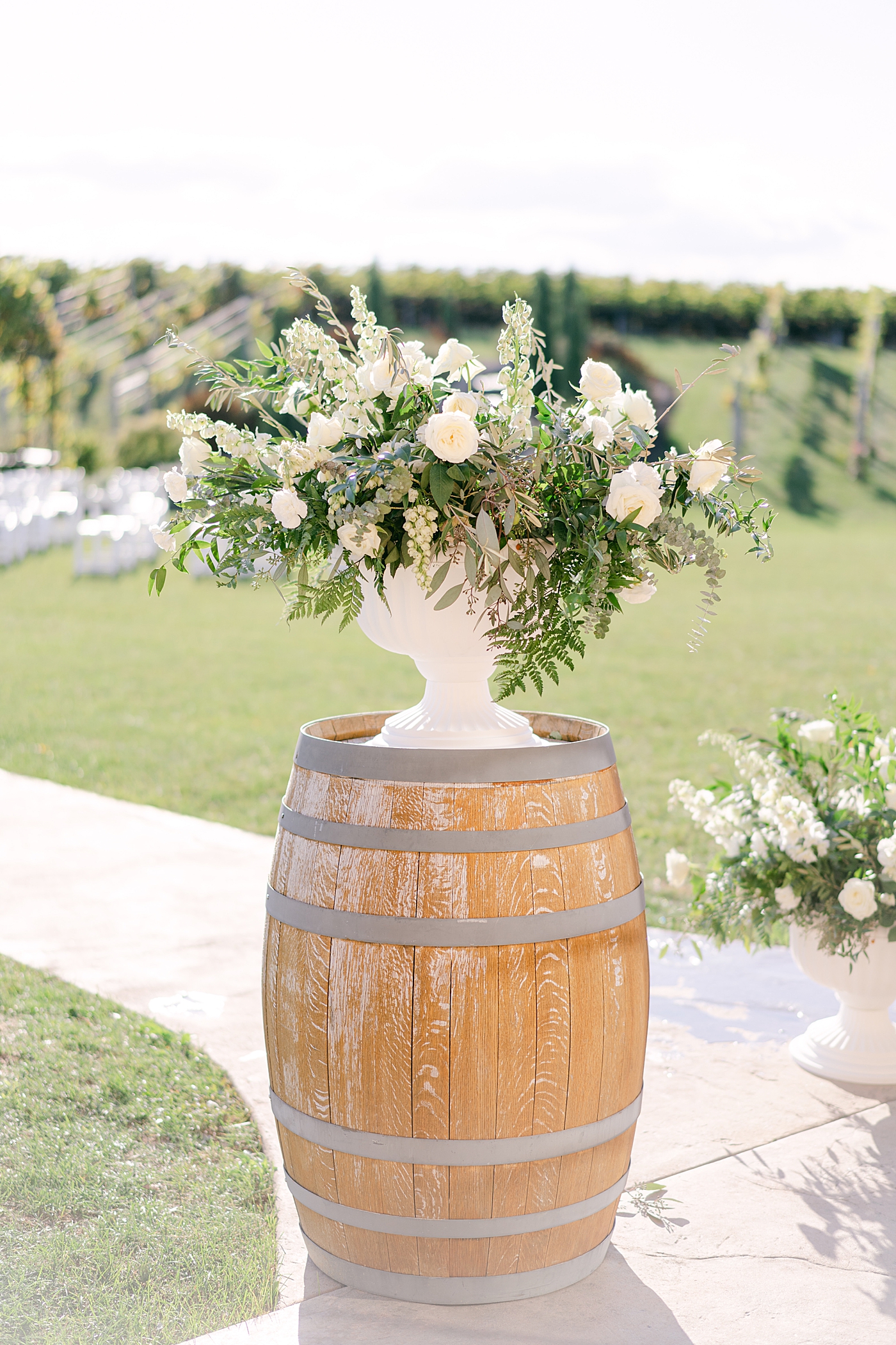 White wedding flowers on a wine barrel | Photo by Hope Helmuth Photography