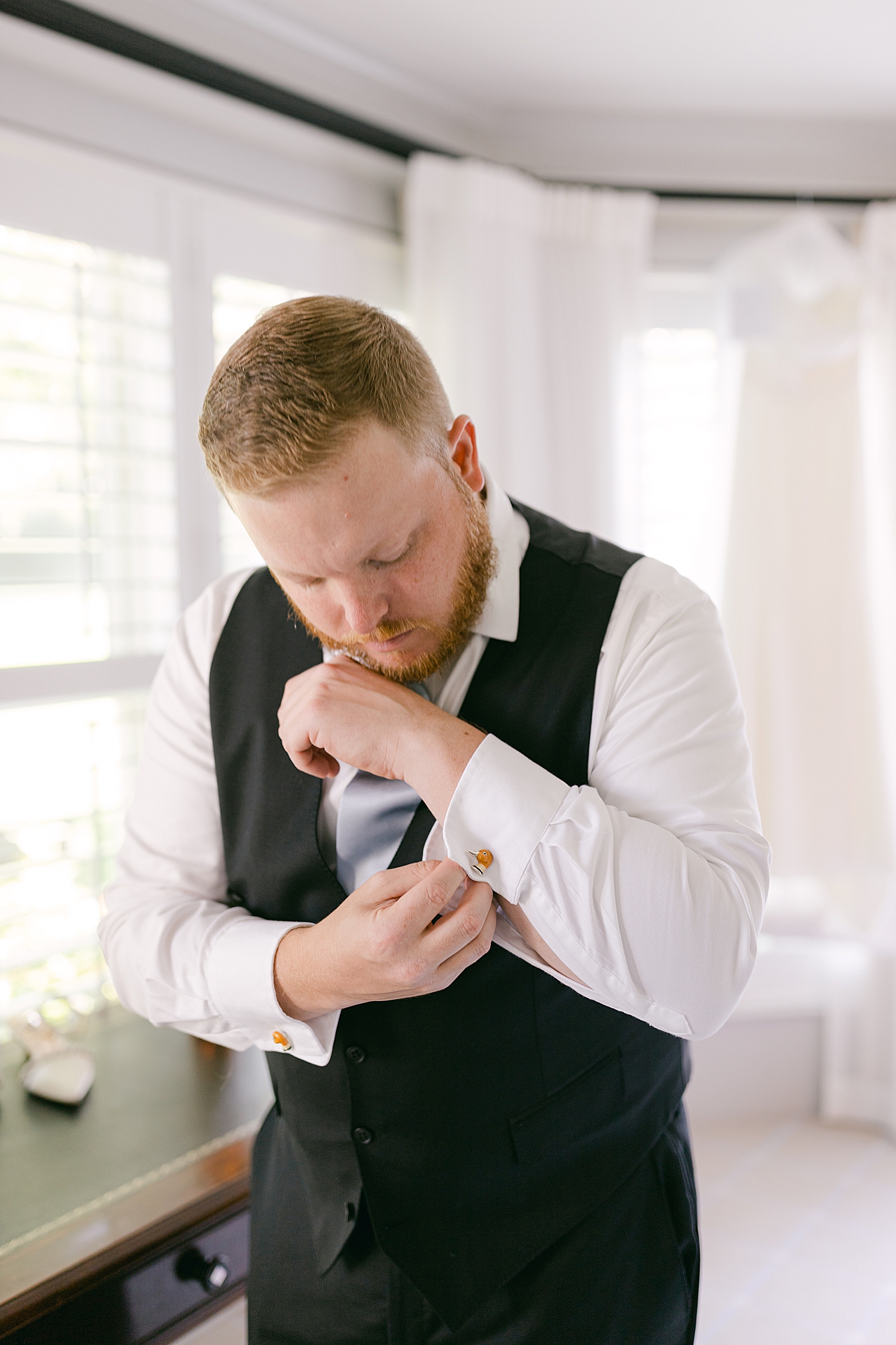 Groom adjusting his cufflinks before his wedding | Photo by Hope Helmuth Photography