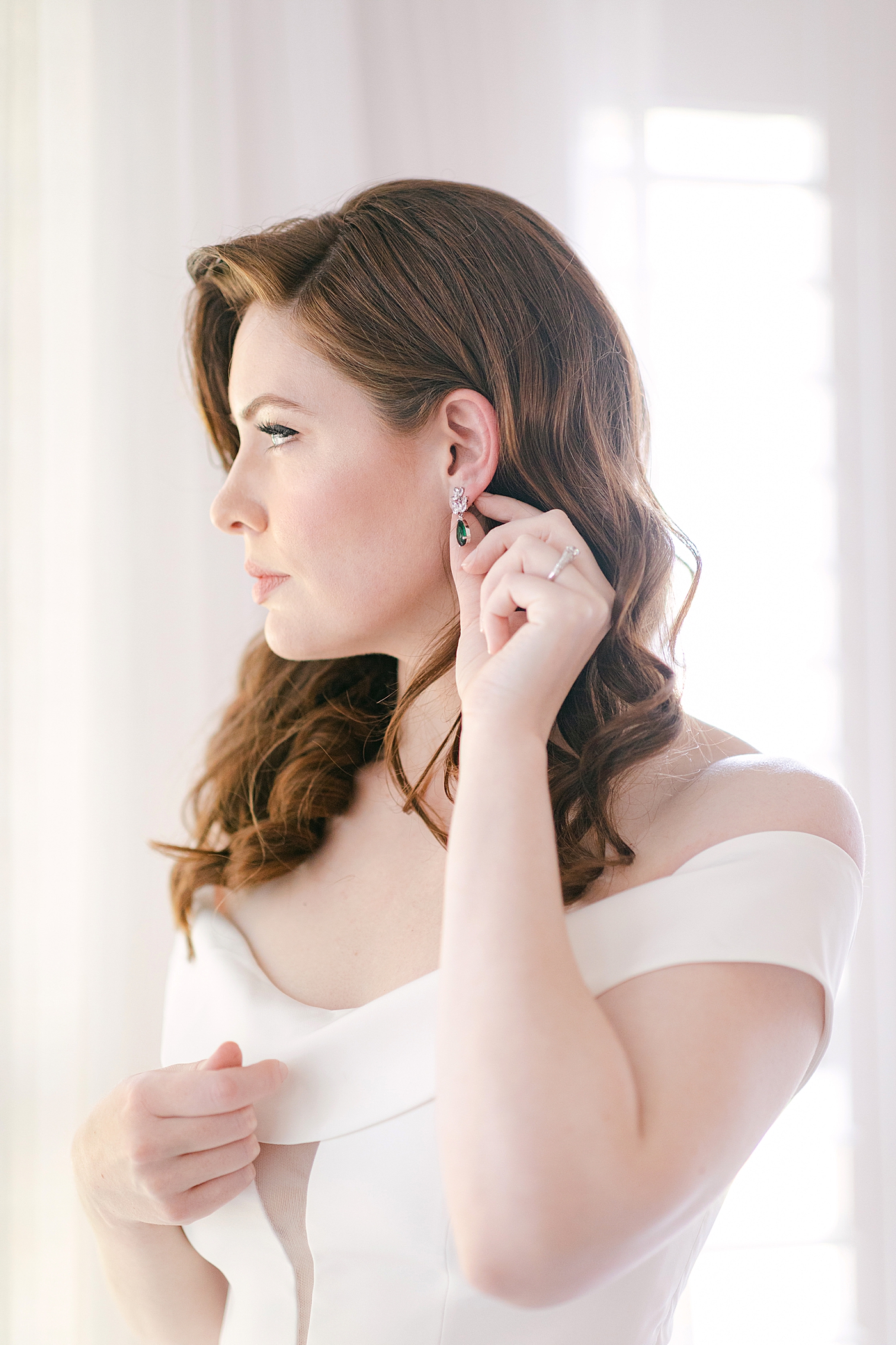 Bride putting in her earrings | Photo by Hope Helmuth Photography