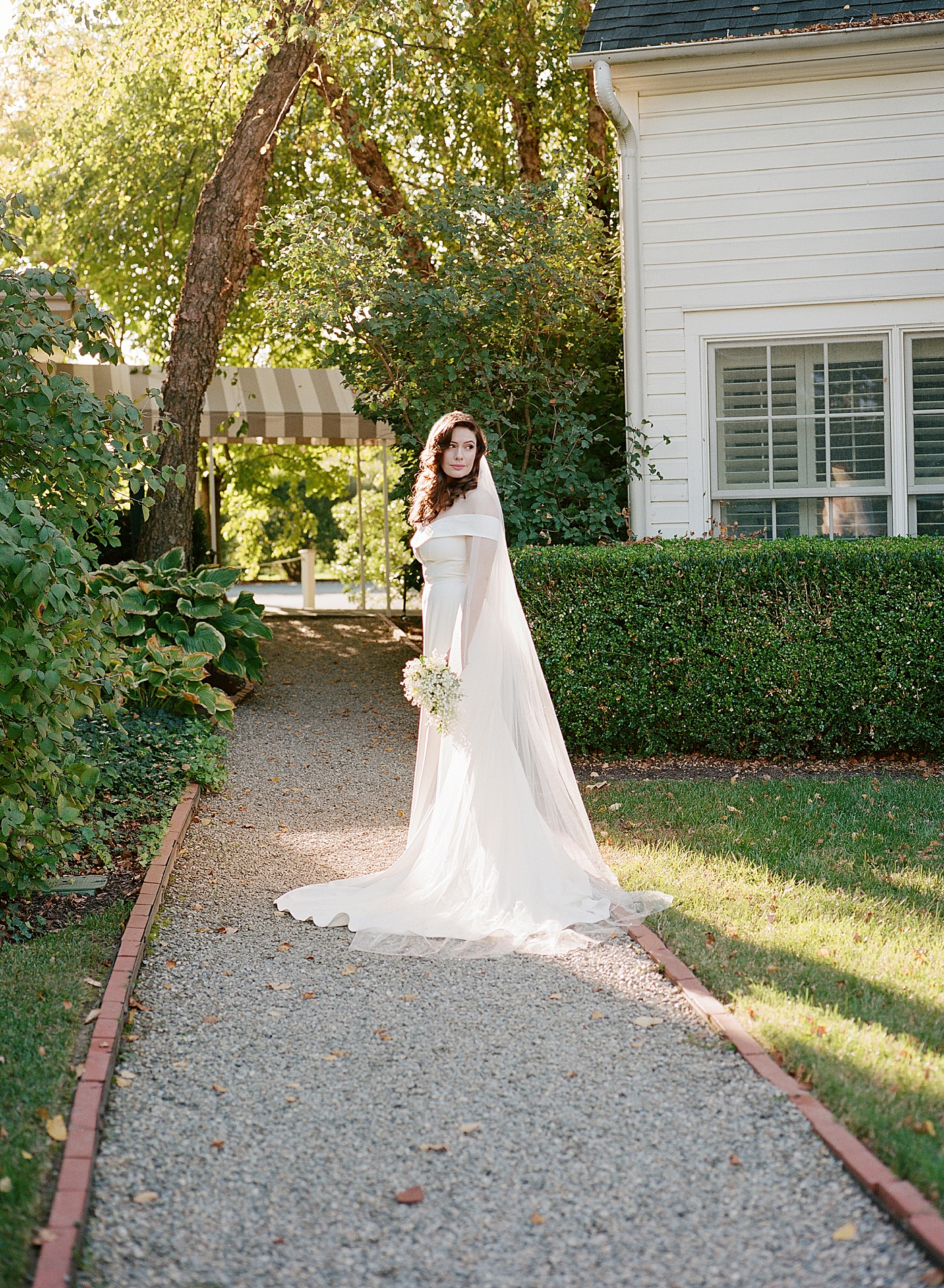Bride standing on a path holding her bouquet | Photo by Hope Helmuth Photography