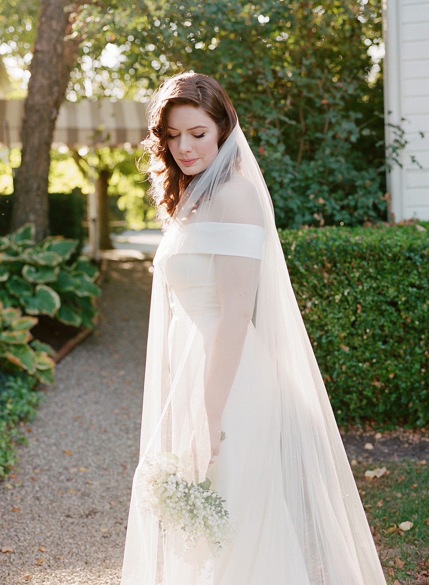 Bride posing for a portrait in a garden | Photo by Hope Helmuth Photography