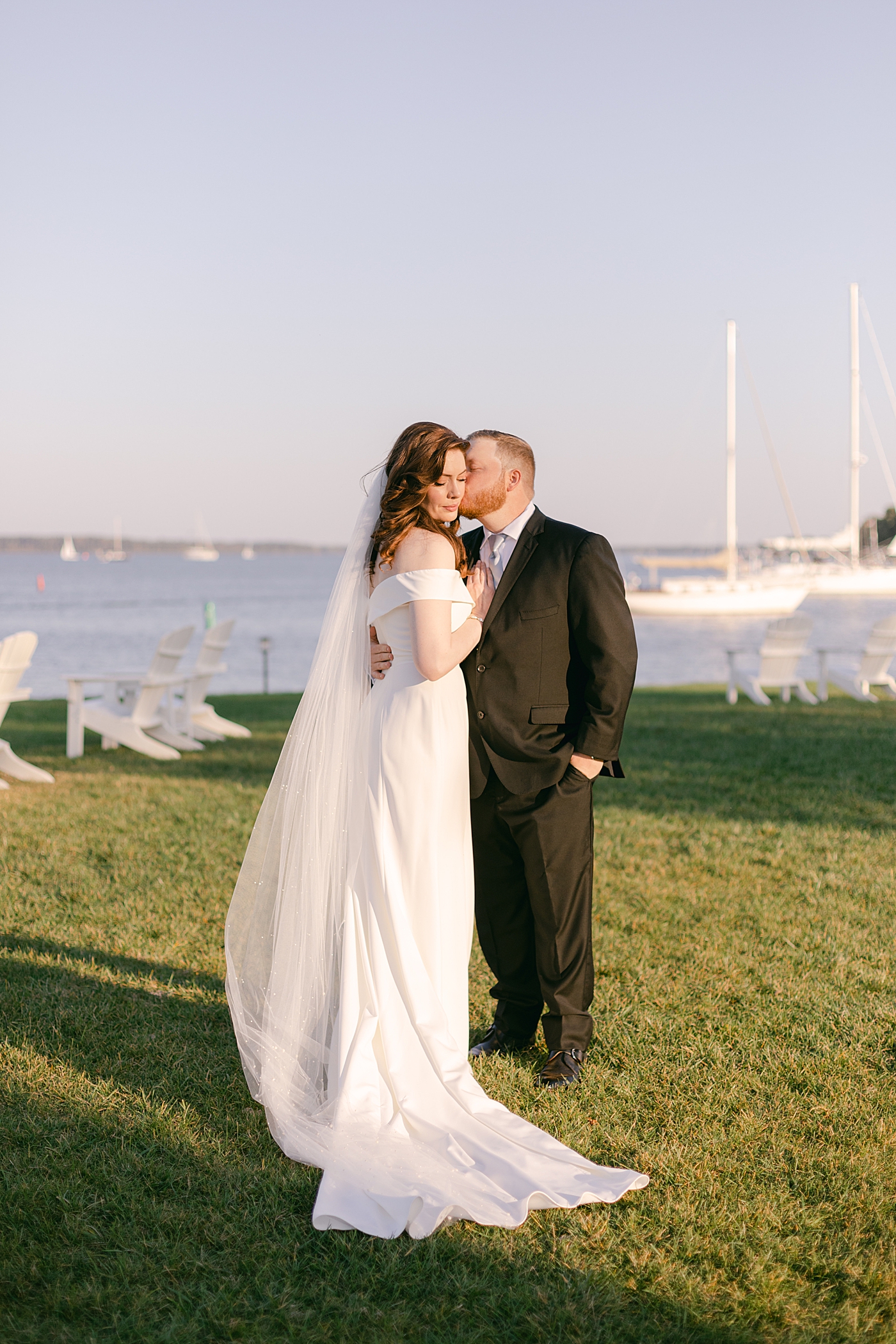 Bride and groom kissing near the water at their Inn at perry cabin wedding| Photo by Hope Helmuth Photography