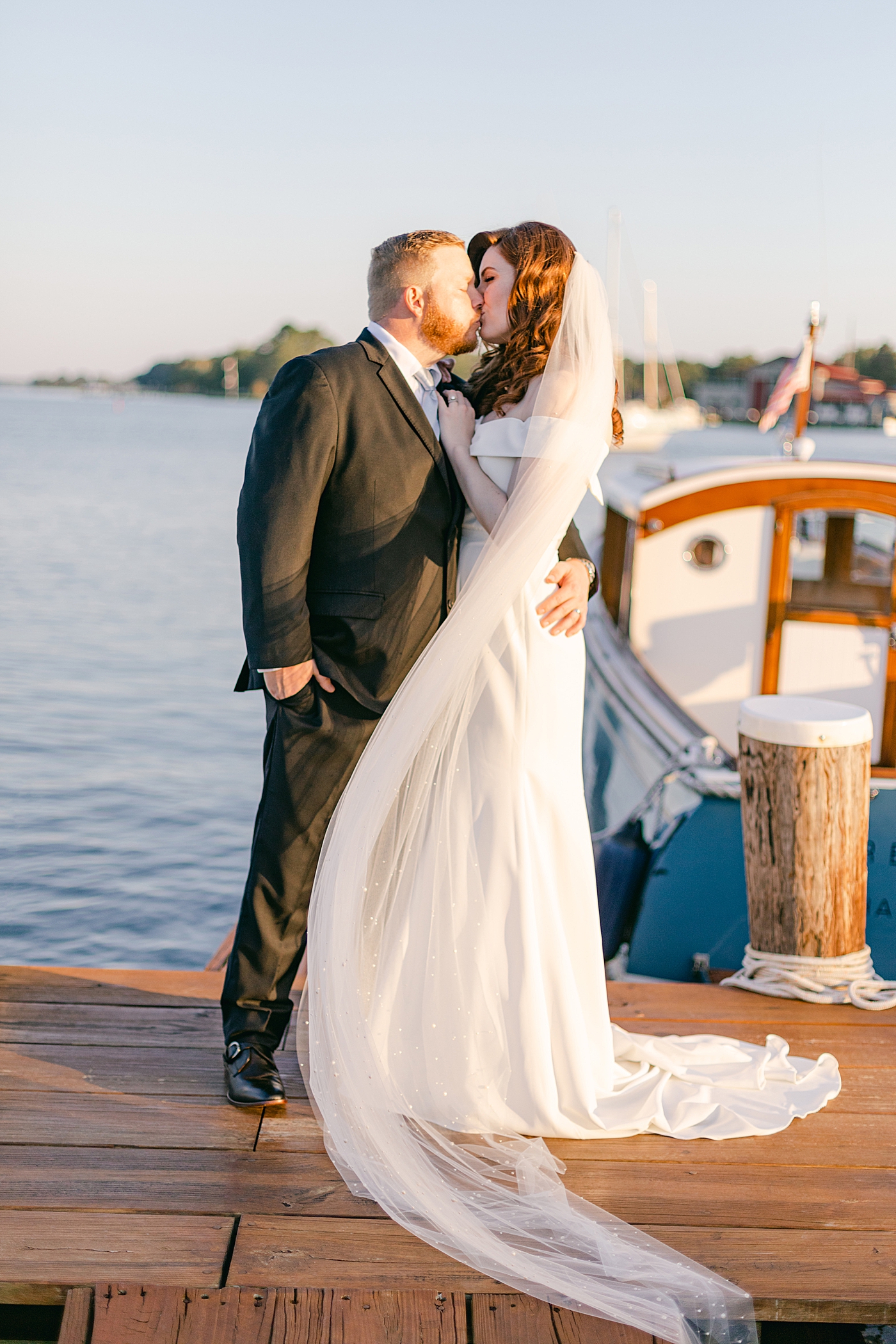 Bride and groom kissing on a dock during their wedding at the inn at perry cabin| Photo by Hope Helmuth Photography