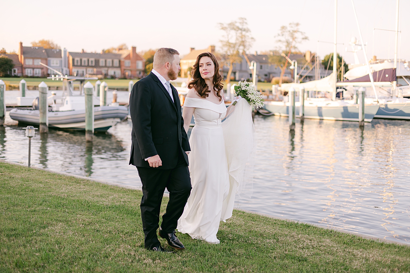 Bride and groom walking near the harbor at their Inn at Perry Cabin wedding| Photo by Hope Helmuth Photography