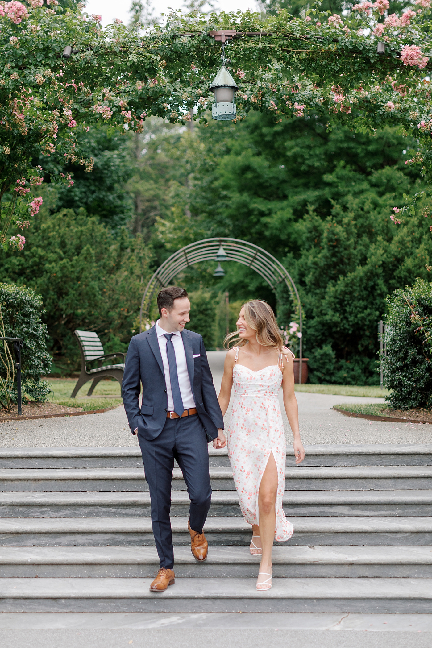 Couple walking down stairs holding hands and smiling | Photo by Hope Helmuth Photography