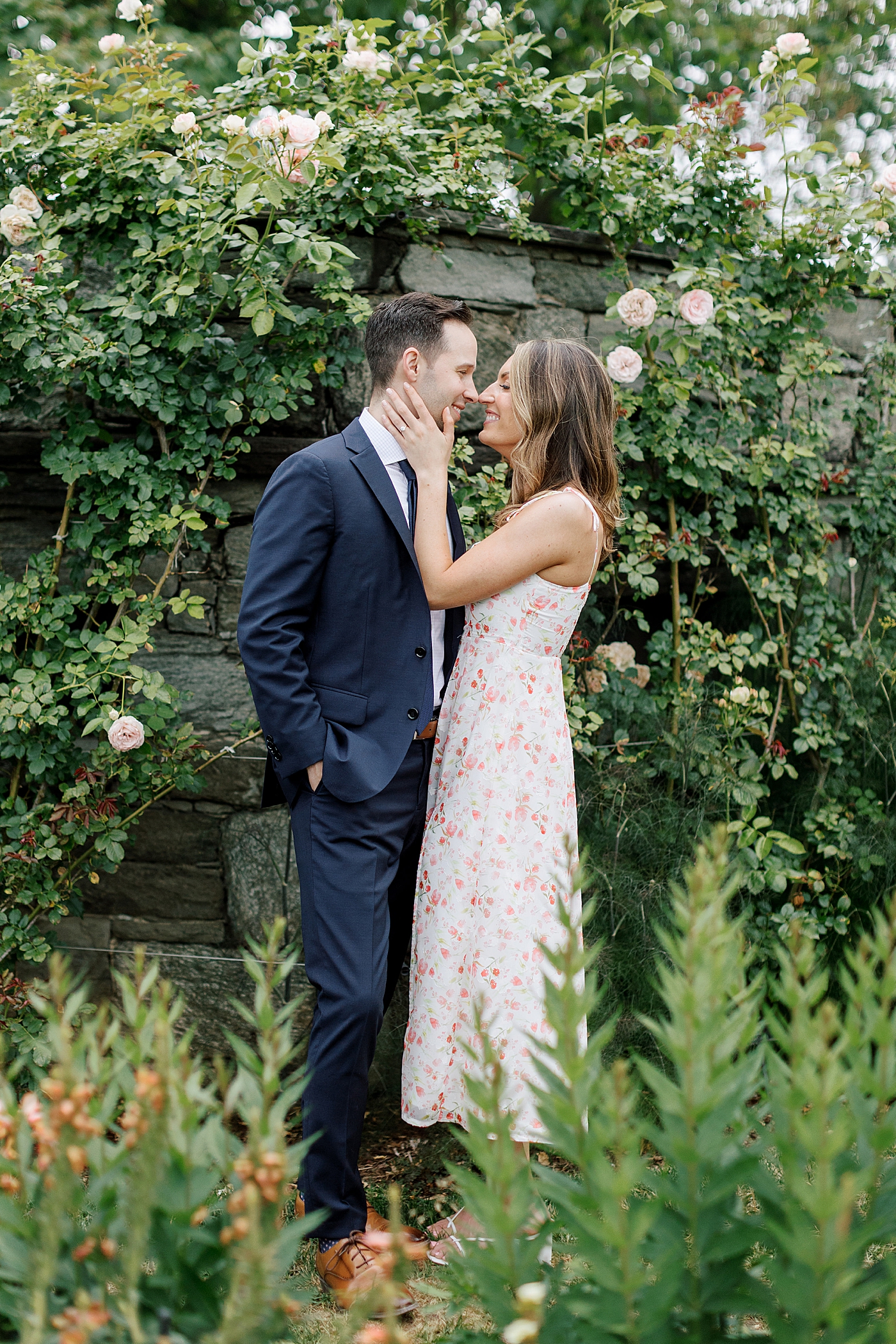 Couple kissing in front of a rose wall | Engagement Session Guides by Hope Helmuth Photography