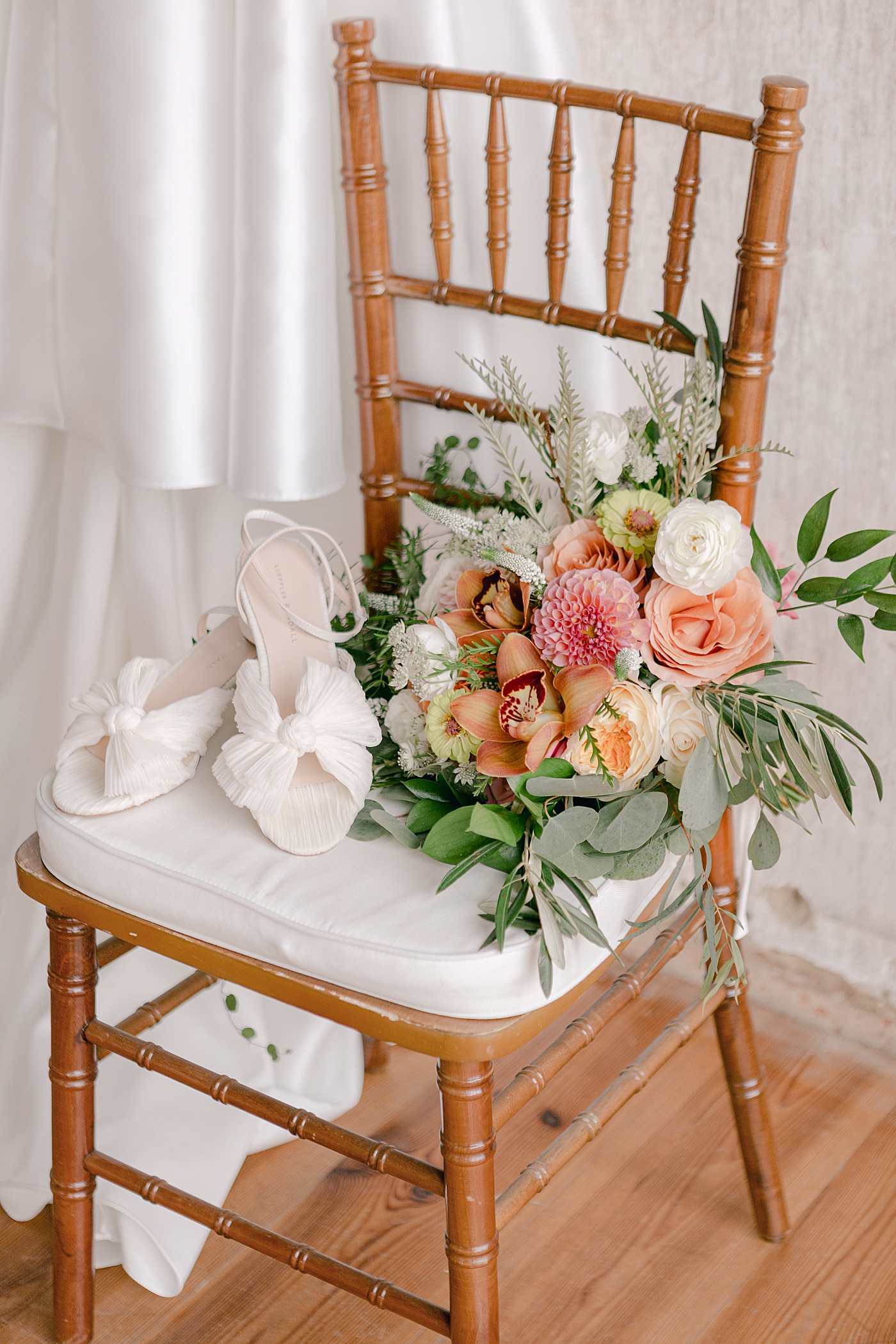 Bridal shoes sitting on a chair with bouquet | Photo by Hope Helmuth Photography