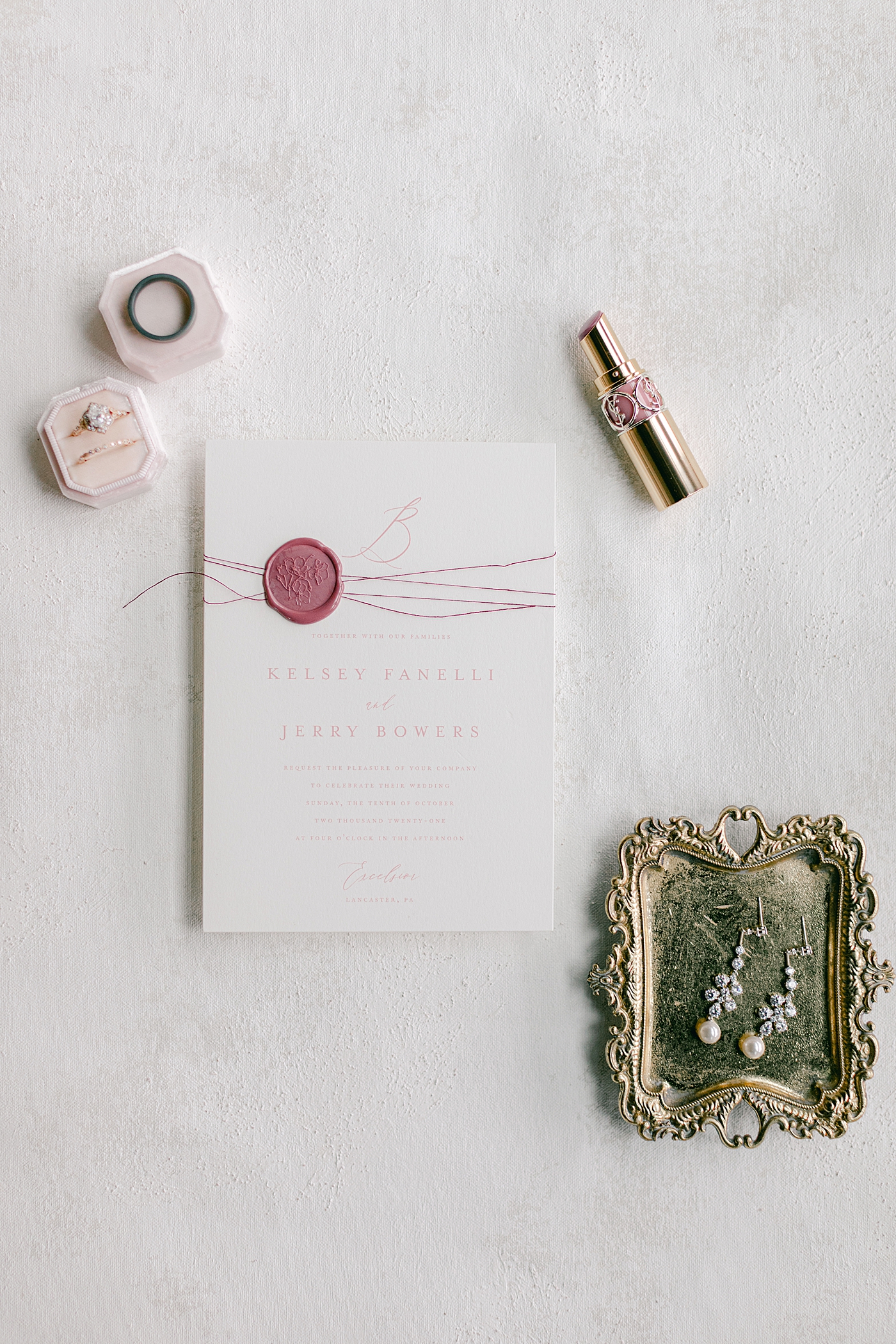 Wedding invitation styled with wedding rings and lipstick | Photo by Hope Helmuth Photography