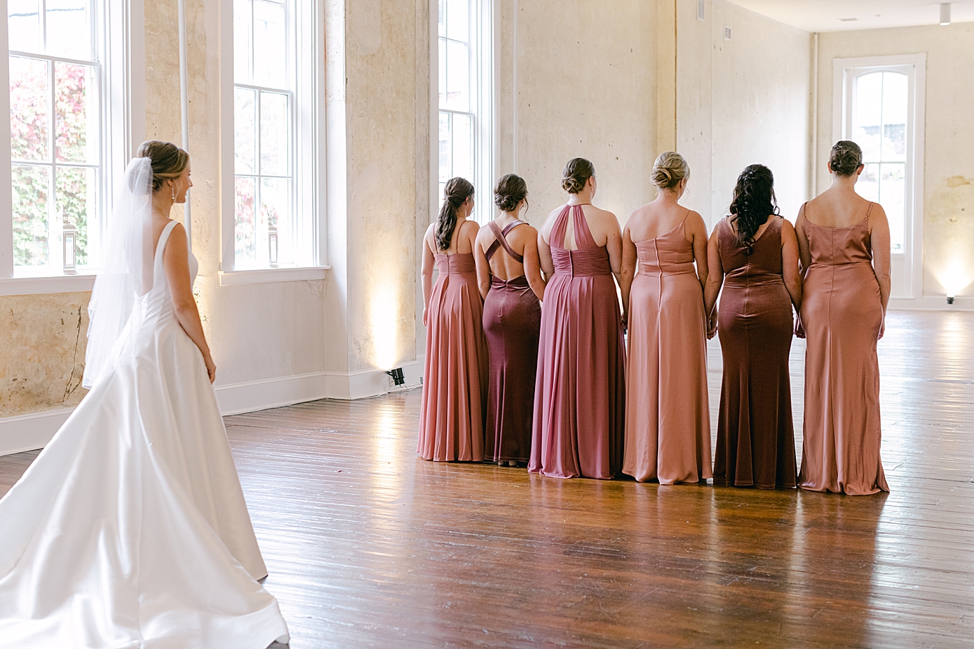 Bride doing a first look with her bridesmaids | Photo by Hope Helmuth Photography