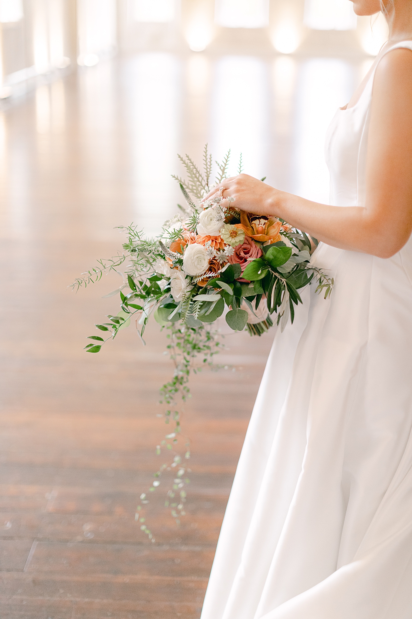 Bride adjusting flowers in her bouquet | Photo by Hope Helmuth Photography
