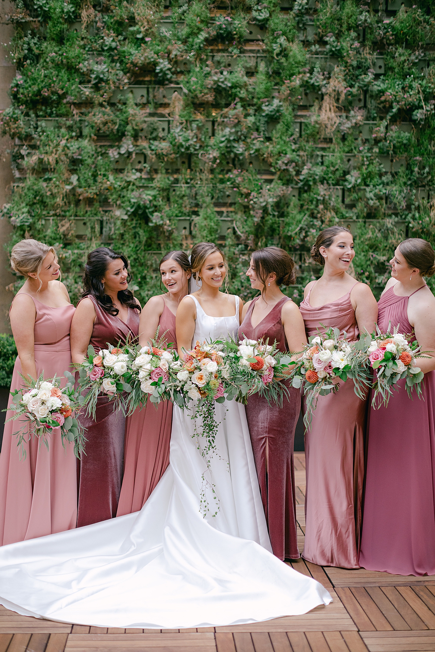 Bride with her bridesmaids holding their florals | Photo by Hope Helmuth Photography