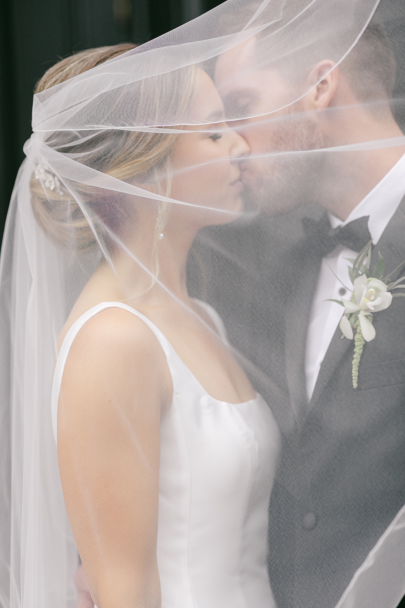 Bride and groom kissing under her veil | Photo by Hope Helmuth Photography