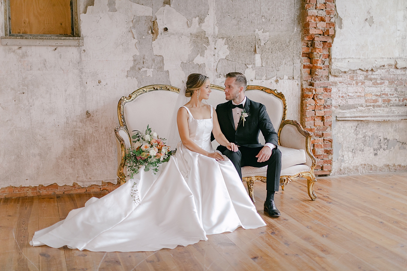 Bride and groom sitting on a sofa | Photo by Hope Helmuth Photography