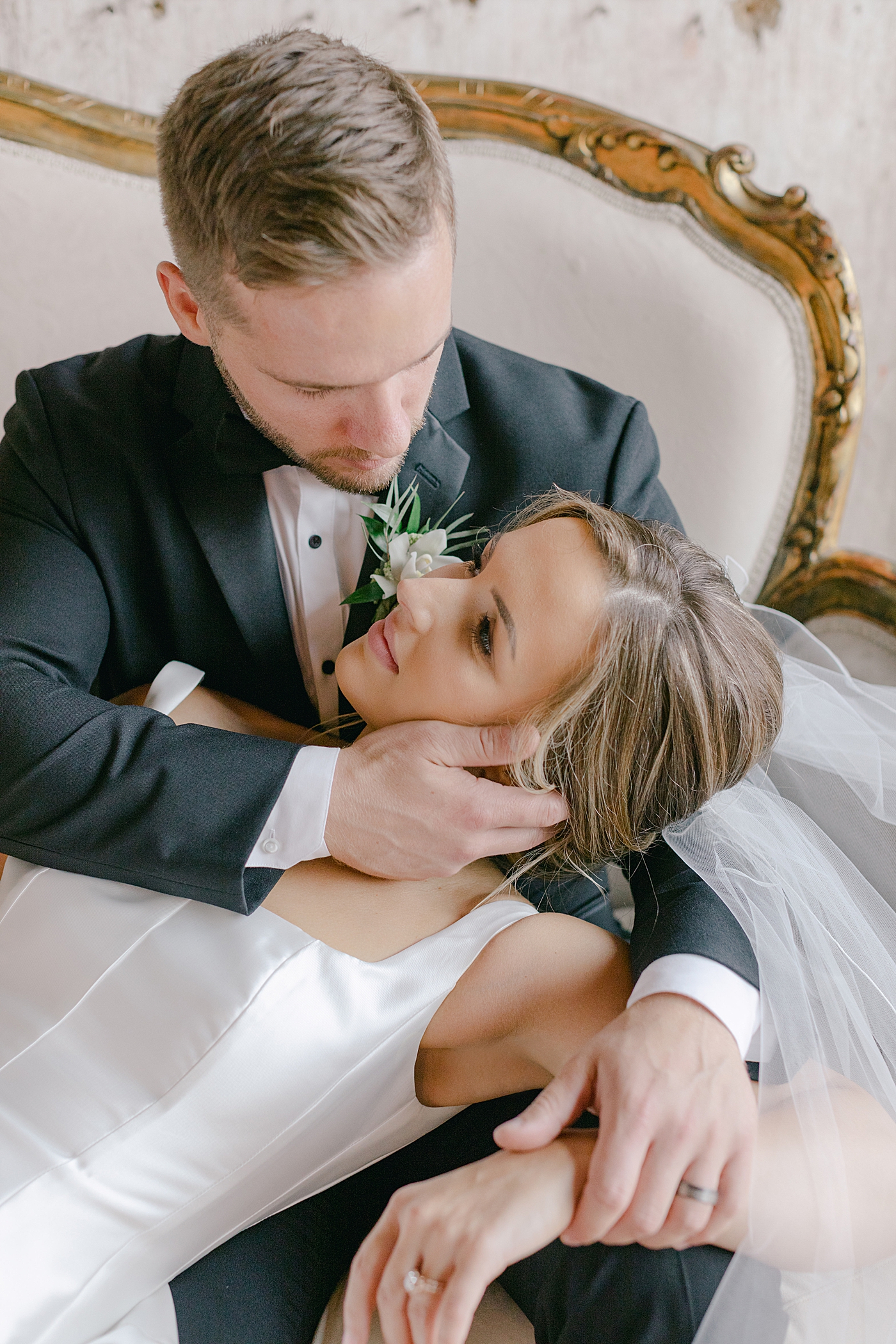 Groom holding brides face while they sit on a sofa | Excelsior PA Wedding Photography by Hope Helmuth Photography