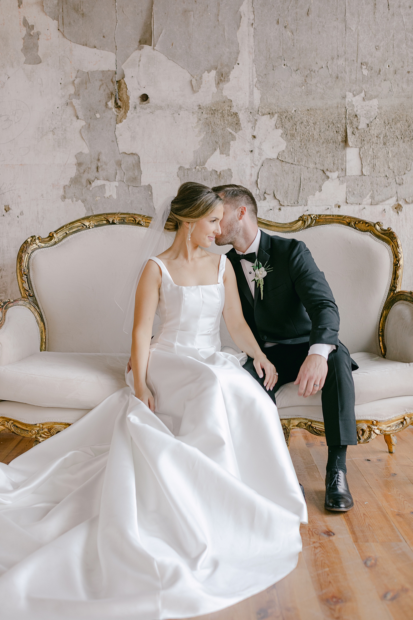 Bride and groom sitting on a sofa together | Photo by Hope Helmuth Photography