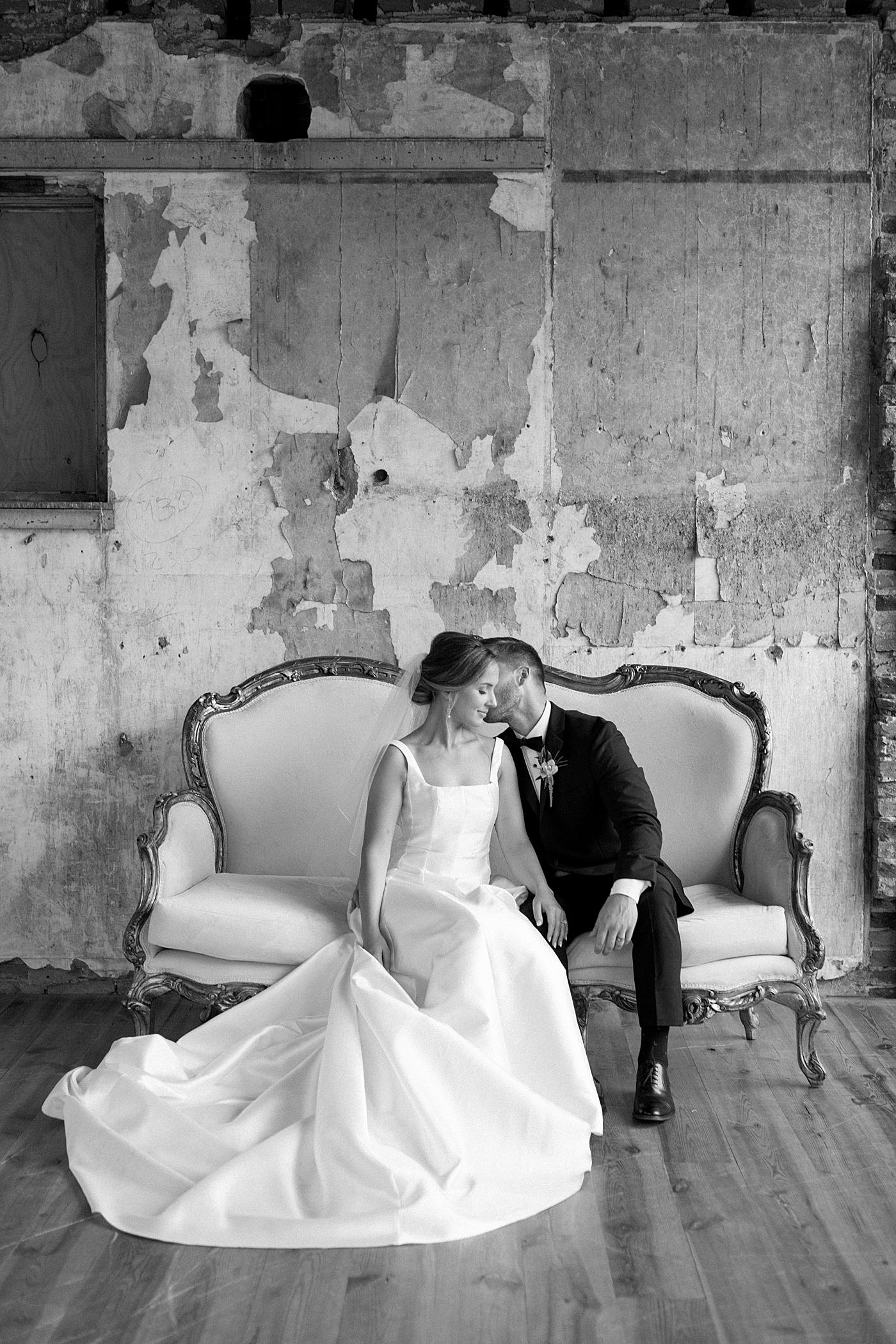 Black and white photo of bride and groom sitting on a sofa | Excelsior PA Wedding Photography by Hope Helmuth Photography
