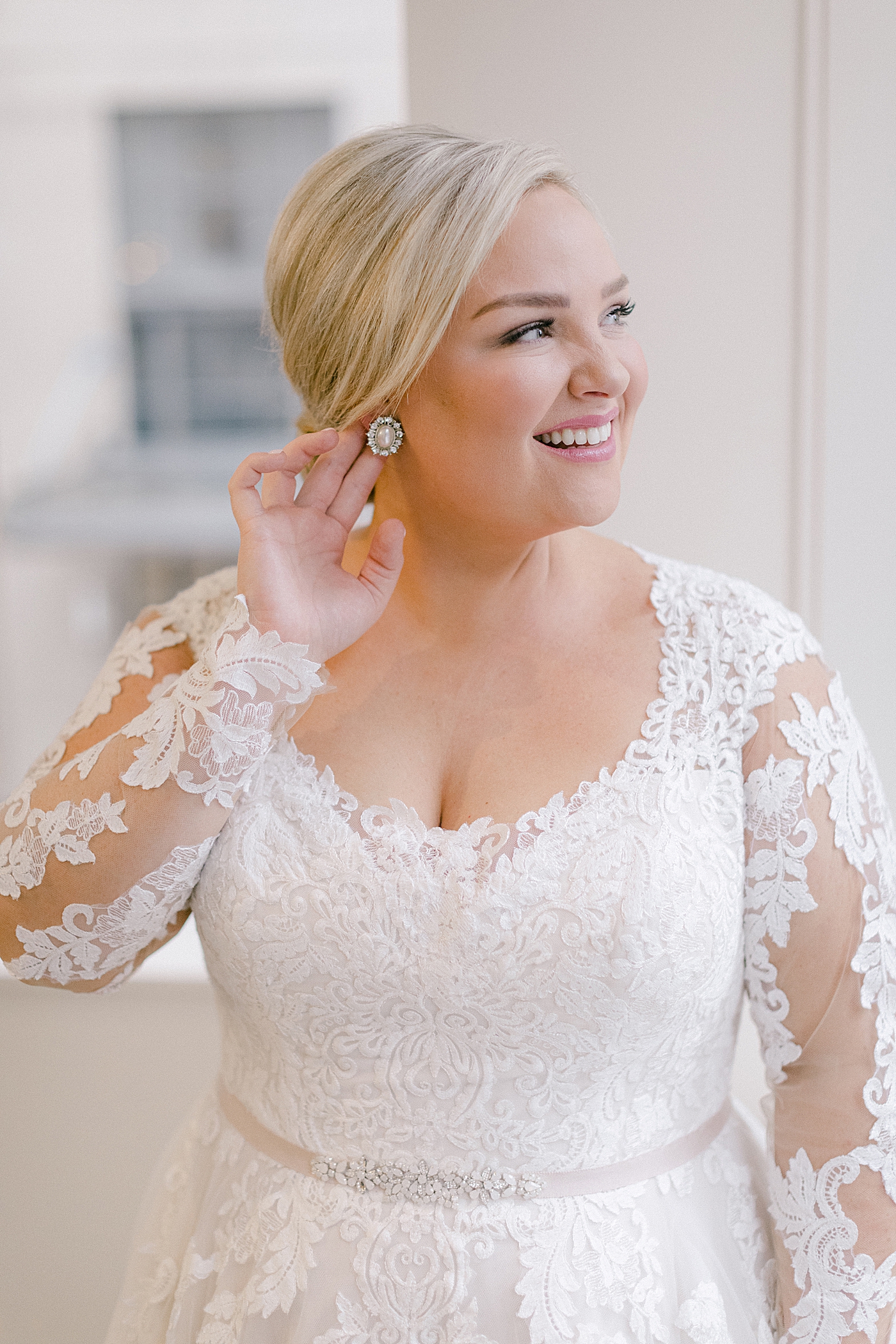 Bride putting on her earrings | Photo by Hope Helmuth Photography
