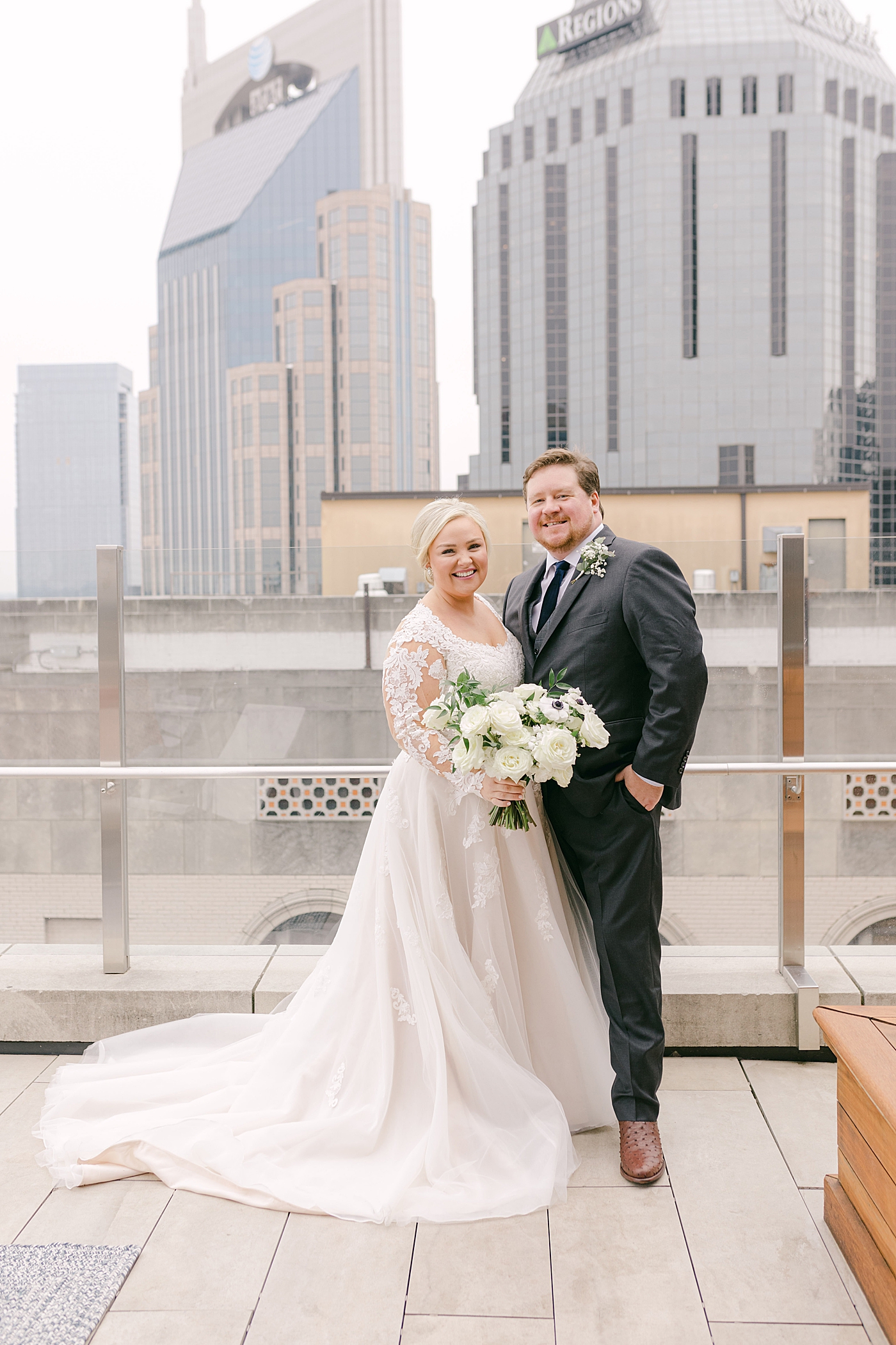 Bride and groom smiling standing on a rooftop in Nashville | Photo by Hope Helmuth Photography