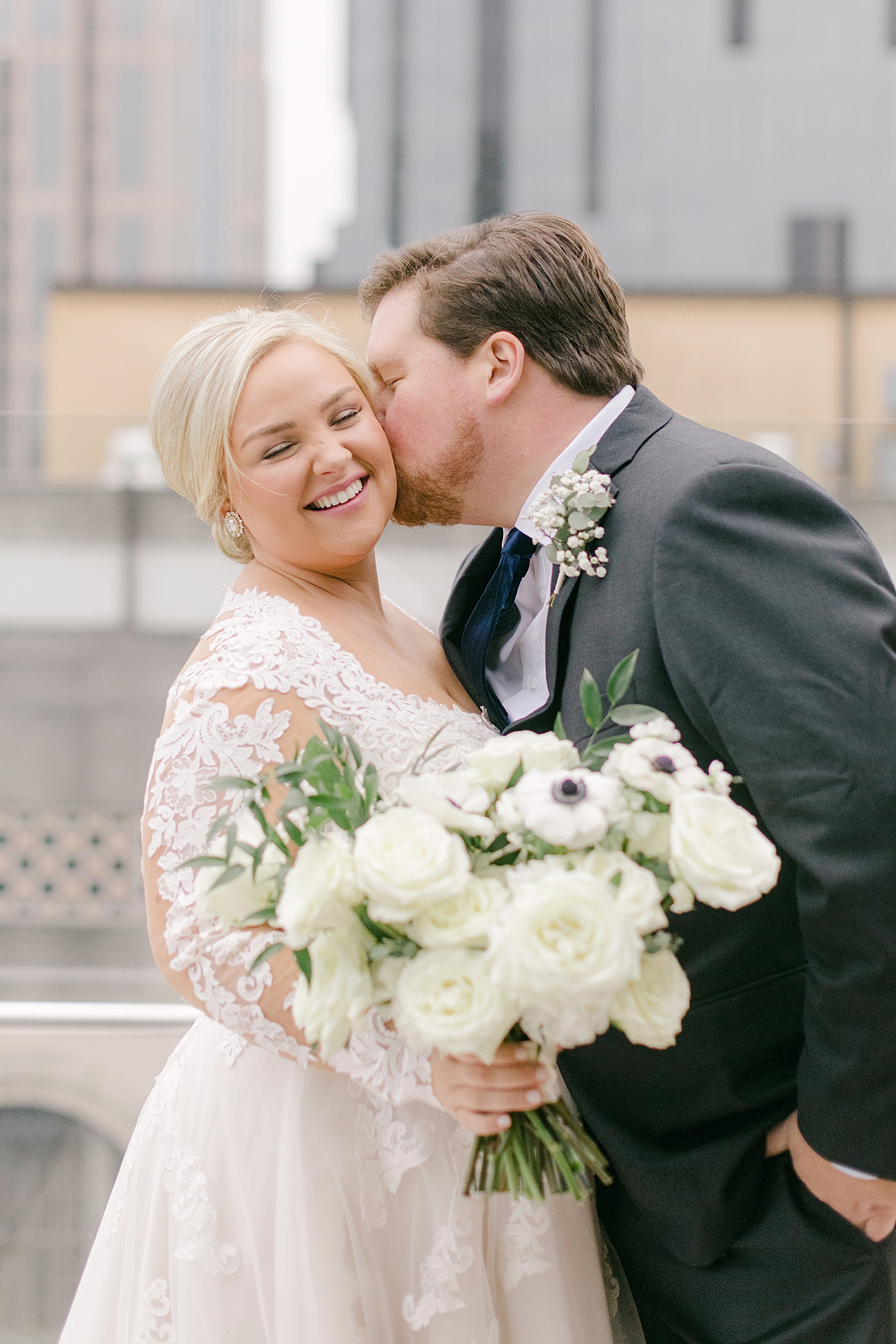 Groom kissing bride on the cheek during Noelle, Nashville Wedding | Photo by Hope Helmuth Photography