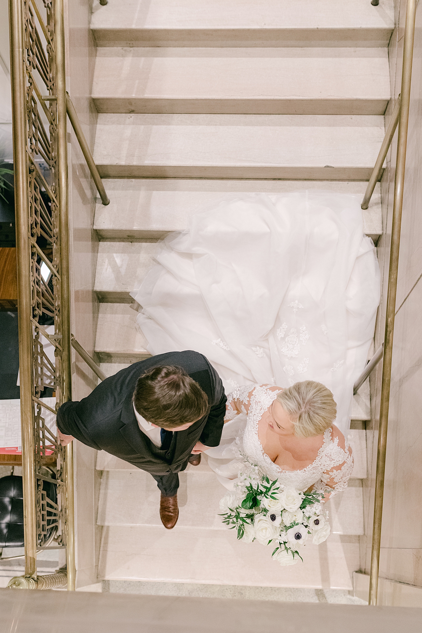 Bride and groom walking down stairs | Photo by Hope Helmuth Photography