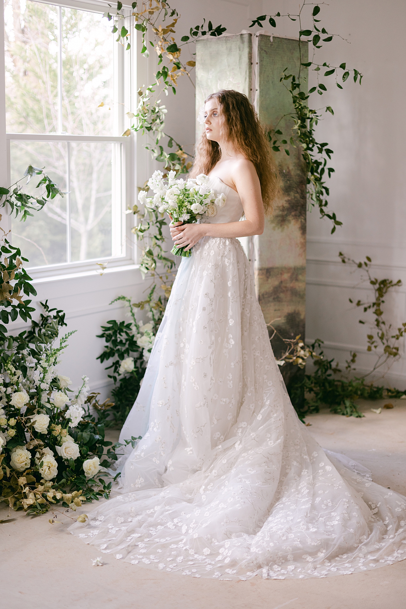Bride holding a bouquet looking out a window during Old World Romance Editorial | Photo by Hope Helmuth Photograpghy