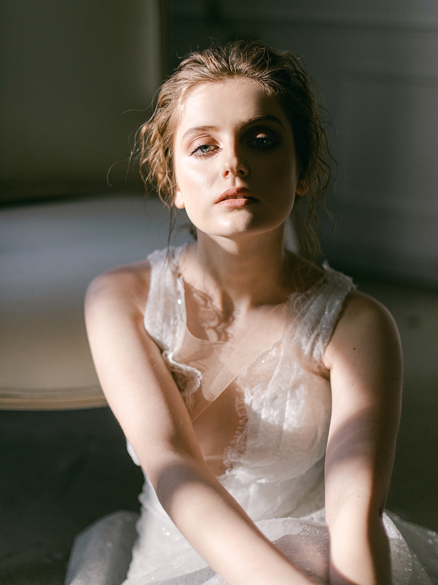 Bride in beautiful harsh lighting sitting on the floor | Photo by Hope Helmuth Photograpghy