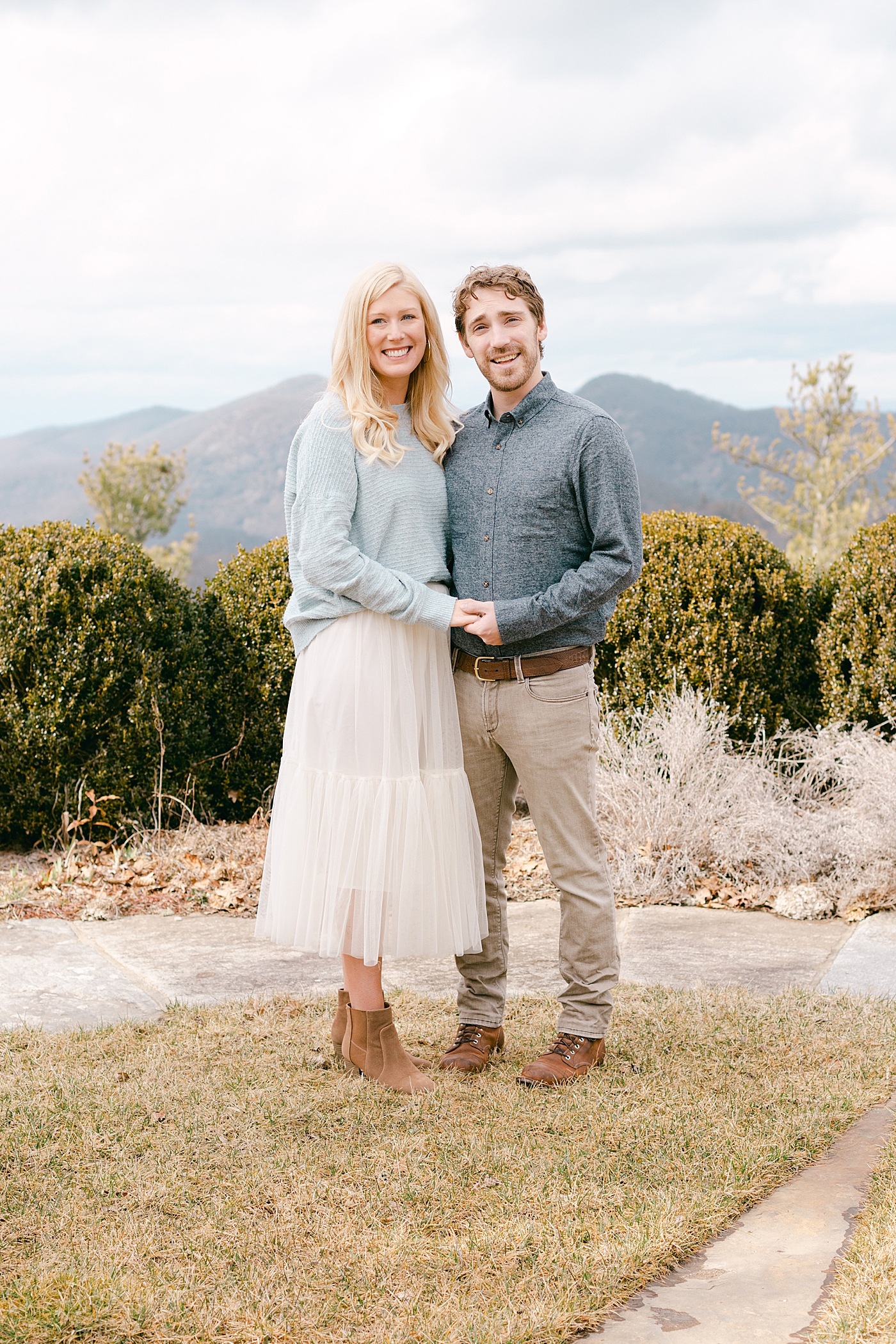 Couple smiling and holding hands during their Highlands Engagement Session | Image by Hope Helmuth Photography