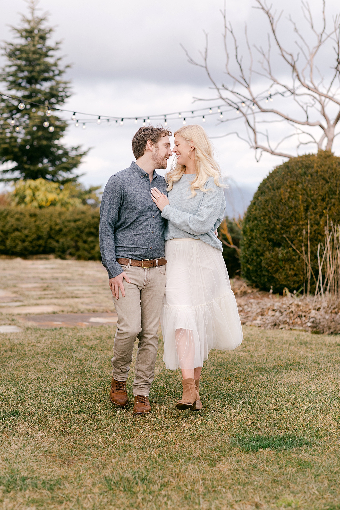 Couple snuggling and walking during their Highlands Engagement Session | Image by Hope Helmuth Photography