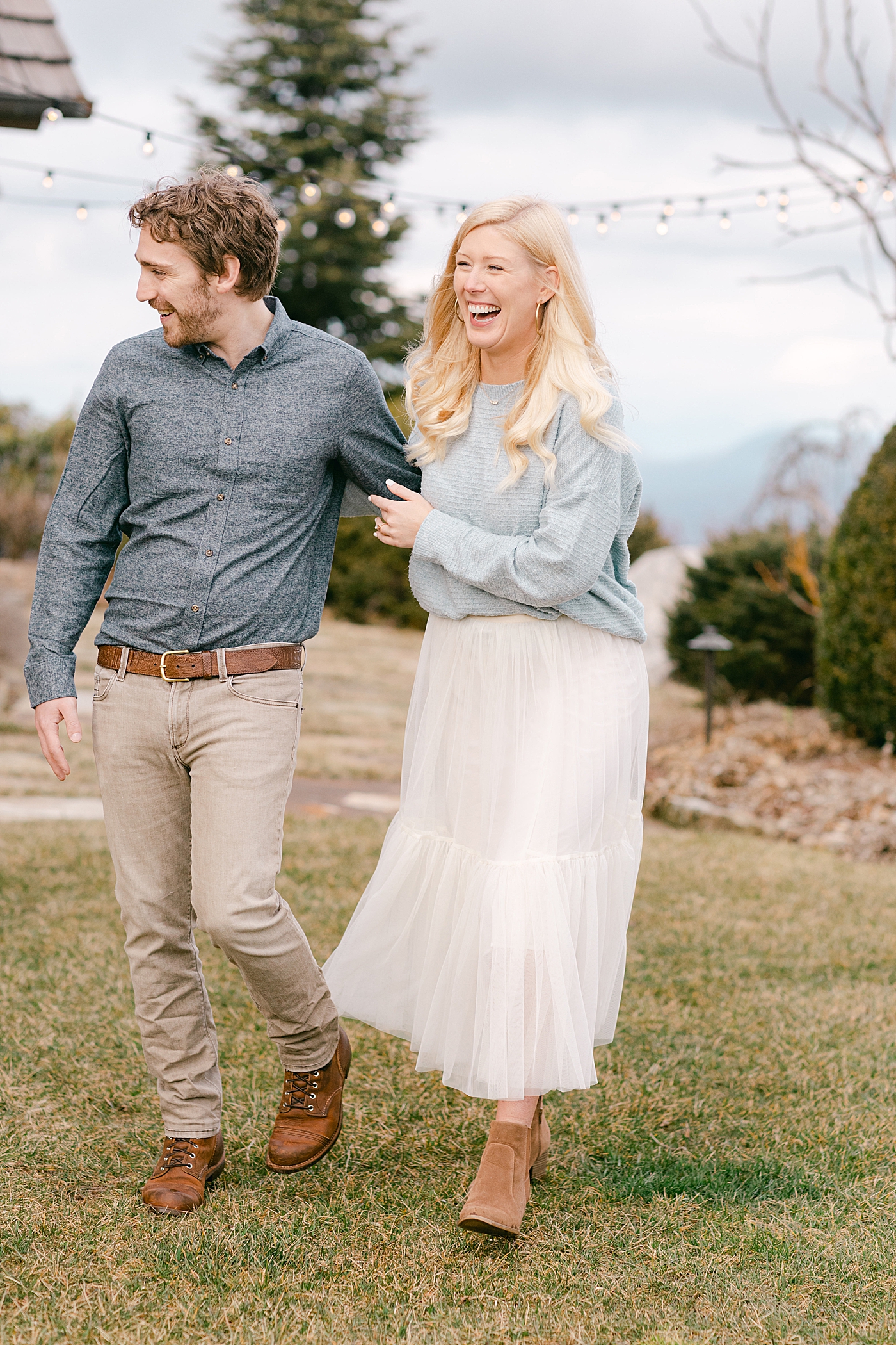 Couple laughing and walking during their Highlands Engagement Session | Image by Hope Helmuth Photography
