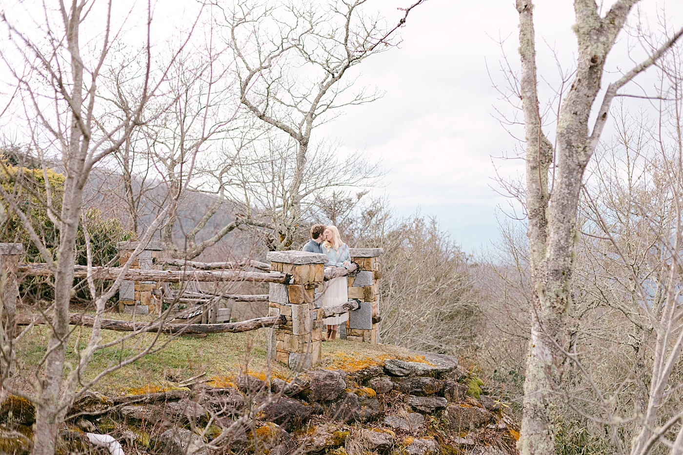 Couple kissing near a fence during their Highlands Engagement Session | Image by Hope Helmuth Photography