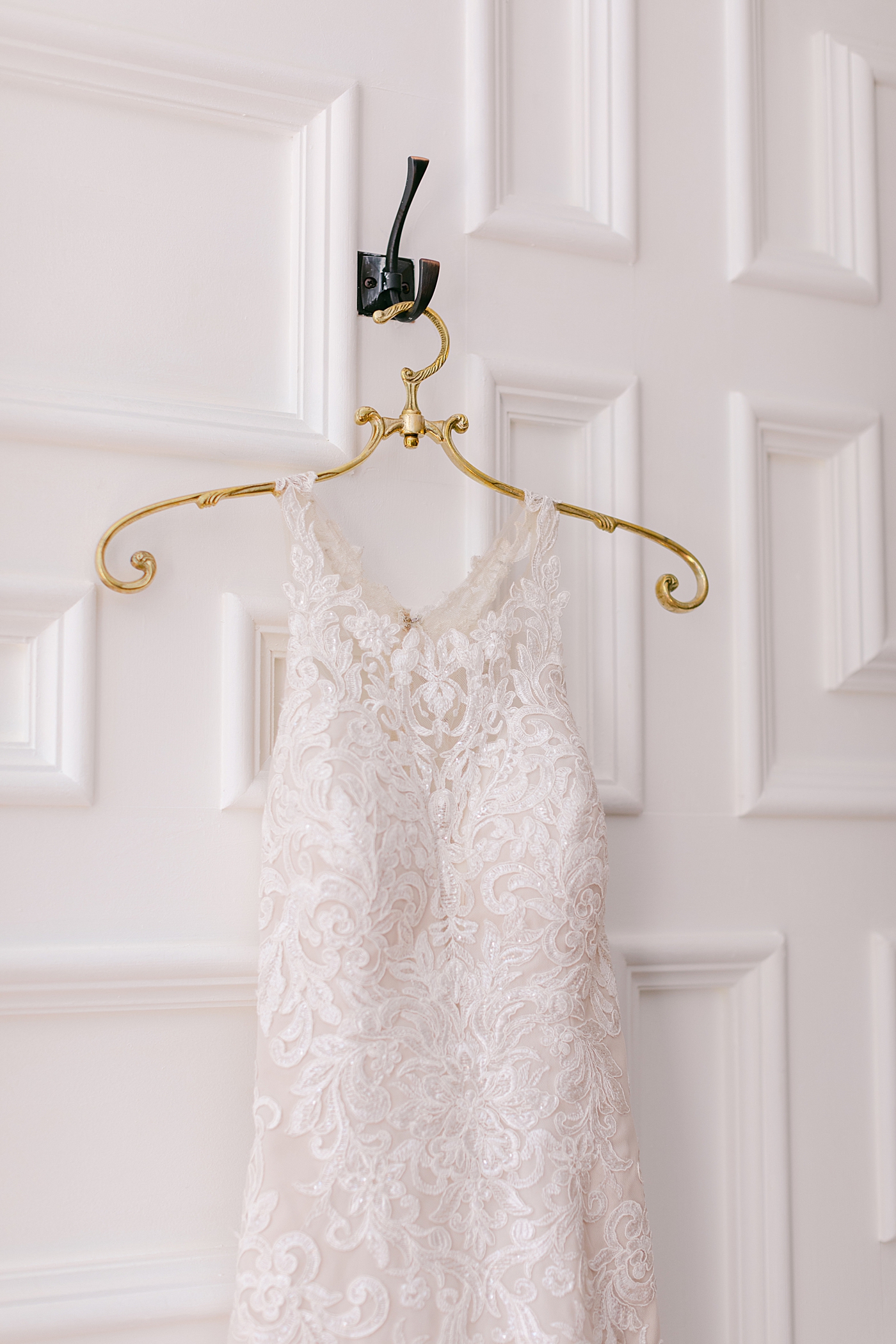 Detail of bridal gown on a gold hanger | Image by Hope Helmuth Photography
