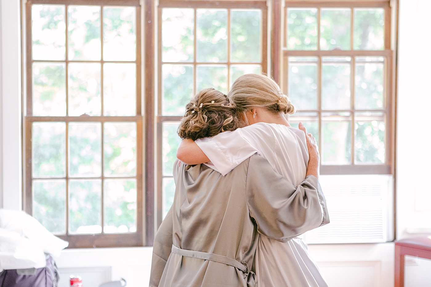 Bride hugging her bridesmaid | Image by Hope Helmuth Photography