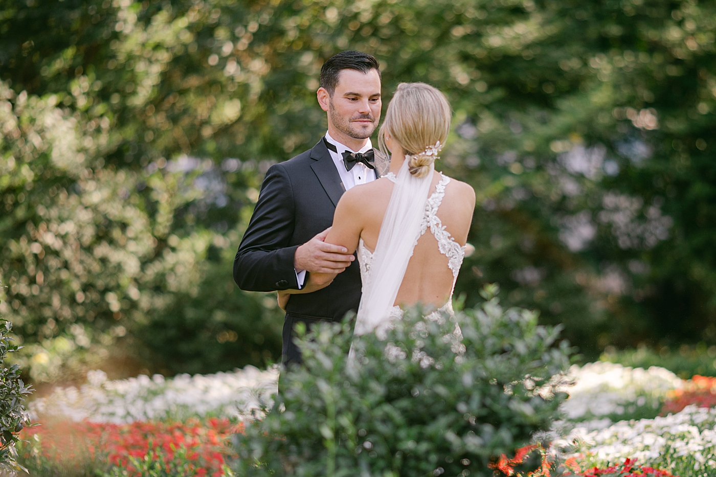 Bride and groom first look in a garden during Hotel du Village Wedding | Image by Hope Helmuth Photography