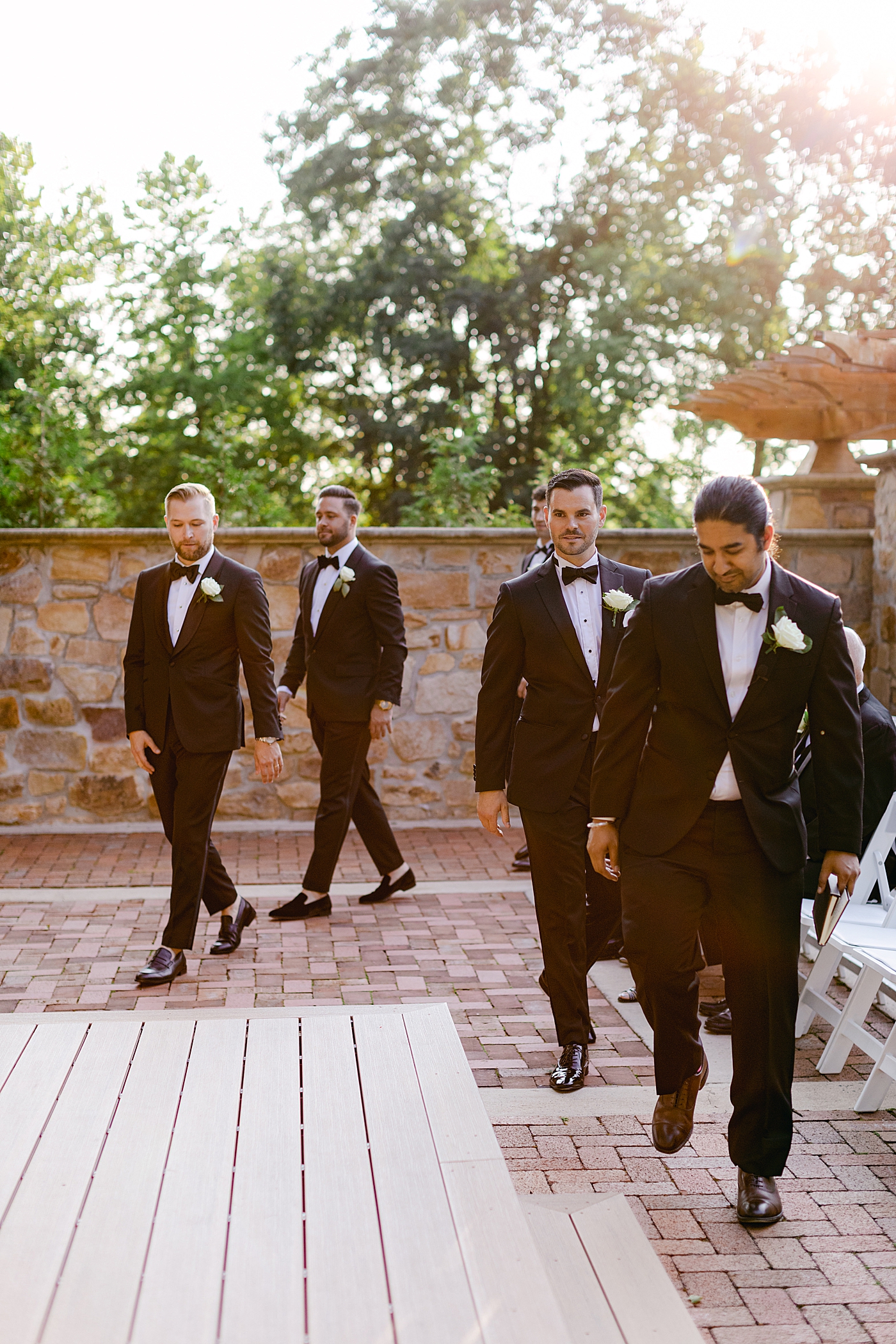 Groomsmen walking to the ceremony location | Image by Hope Helmuth Photography