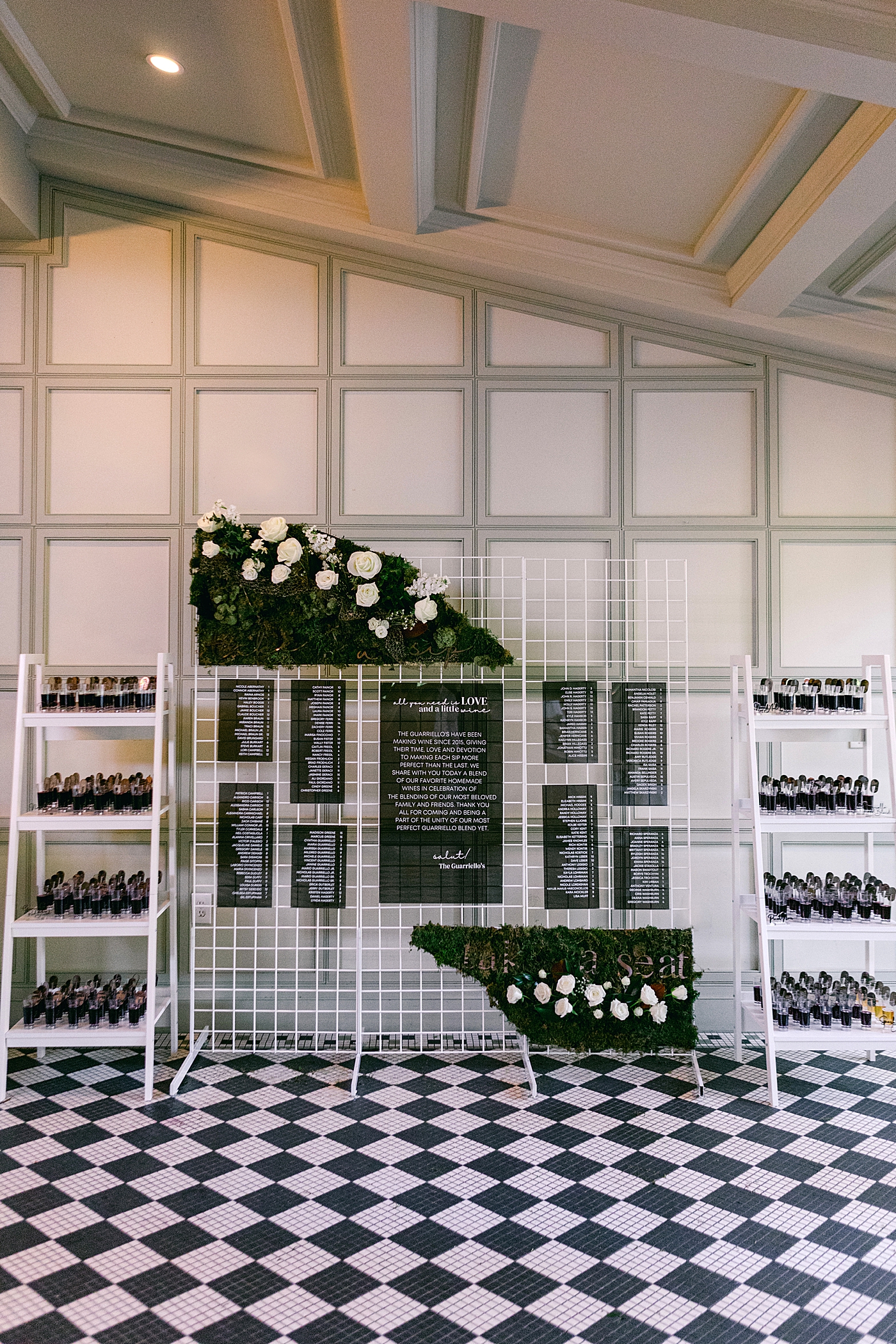 Wedding seating chart with black and white checkered floor during Hotel du Village Wedding | Image by Hope Helmuth Photography